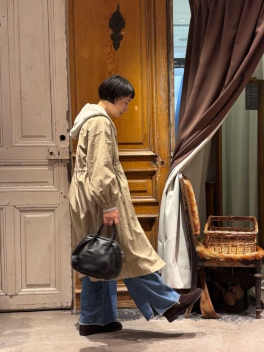 ベージュ系のその他アウター、ブラック系のボストンバッグ、ホワイト系のパーカーを着用したレディースの冬コーディネートの4枚目の写真