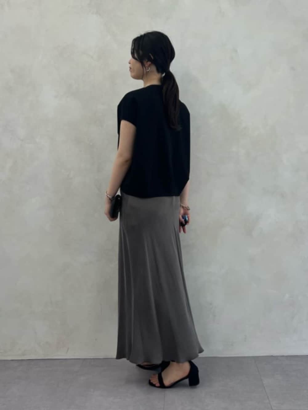 グリーン系のスカート、ブラック系のシャツ/ブラウスを着用したレディースの春コーディネートの3枚目の写真