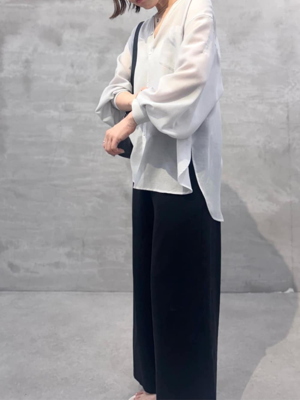 ブラック系のその他パンツ、ブラック系のショルダーバッグ、ホワイト系のサンダルを着用したレディースの冬コーディネートの7枚目の写真