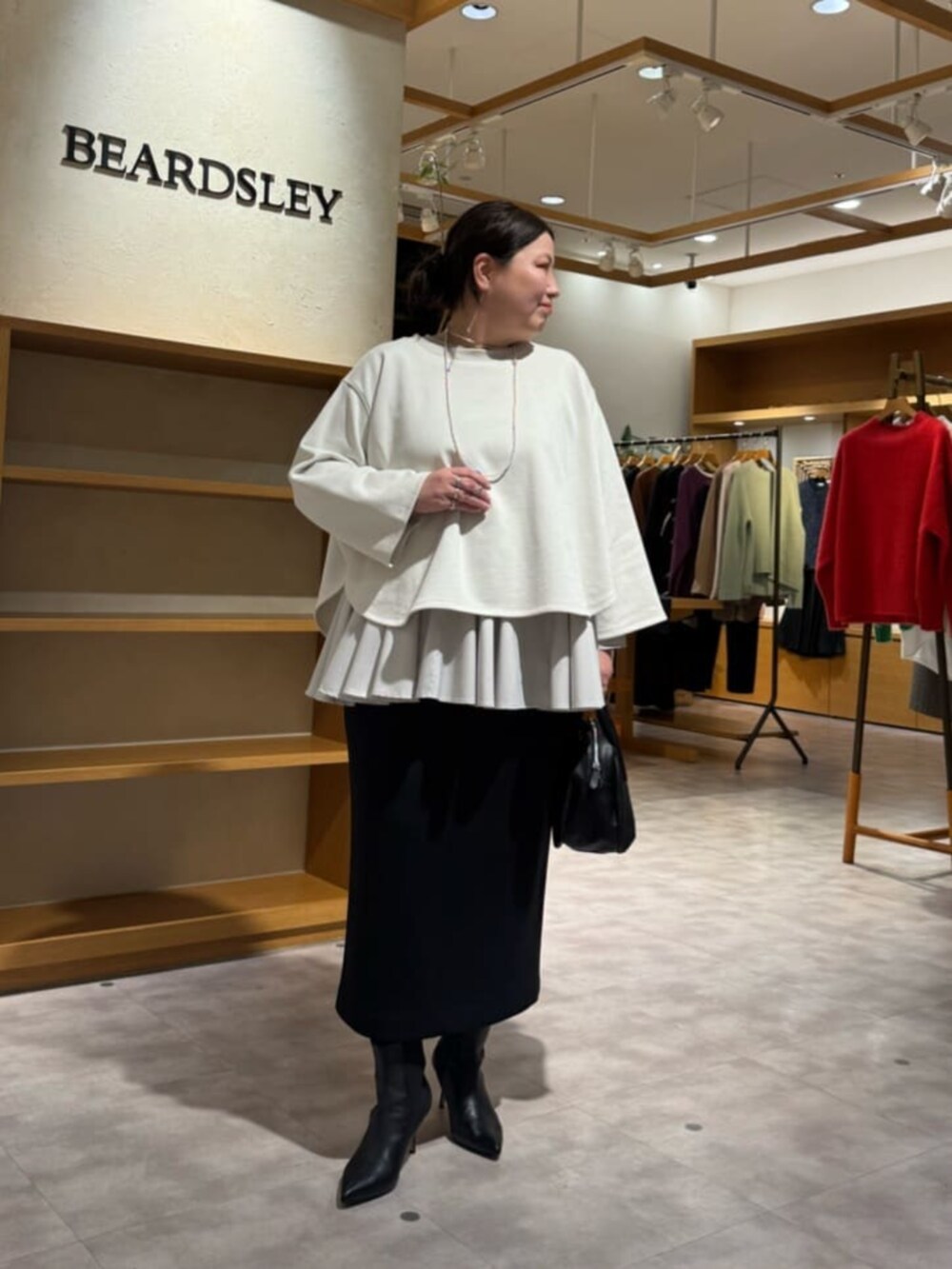 ブラック系のブーツ、ブラック系のスカート、ホワイト系のTシャツ/カットソーを着用したレディースの冬コーディネートの7枚目の写真