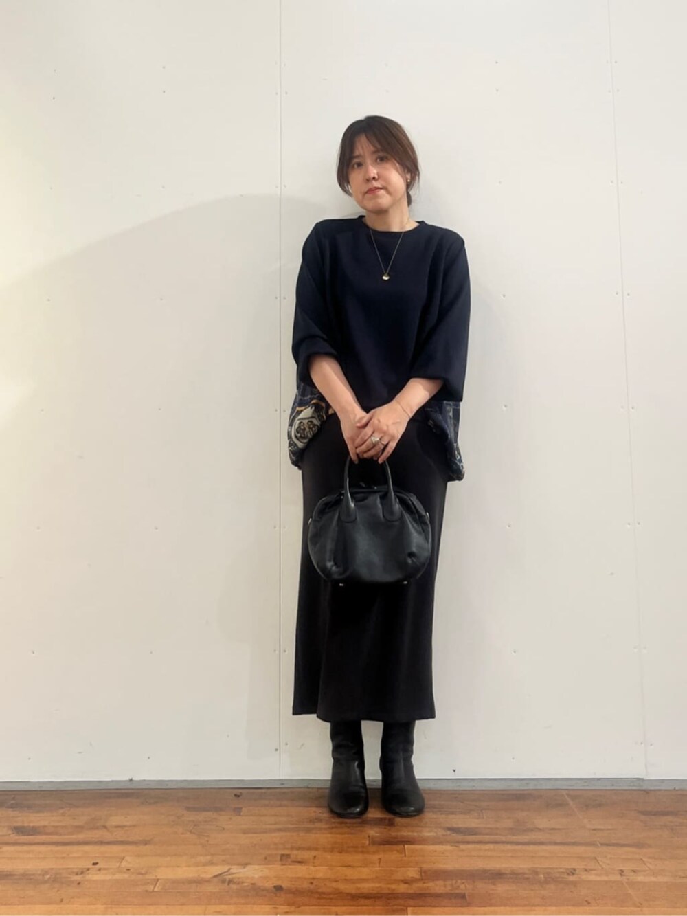 グレー系のスカート、ブラック系のトートバッグ、ブルー系のTシャツ/カットソーを着用したレディースの夏コーディネートの3枚目の写真