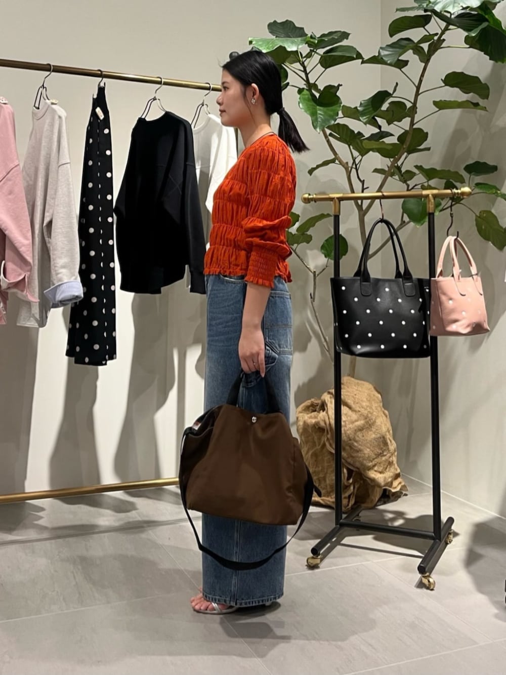 オレンジ系のシャツ/ブラウス、ブラウン系のトートバッグ、ブルー系のその他パンツを着用したレディースの春コーディネートの2枚目の写真