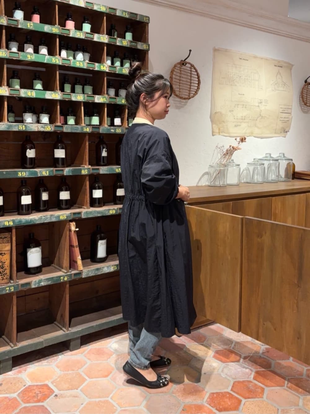 ブルー系のデニムパンツ、ブラック系のボストンバッグ、イエロー系のTシャツ/カットソーを着用したレディースの冬コーディネートの2枚目の写真