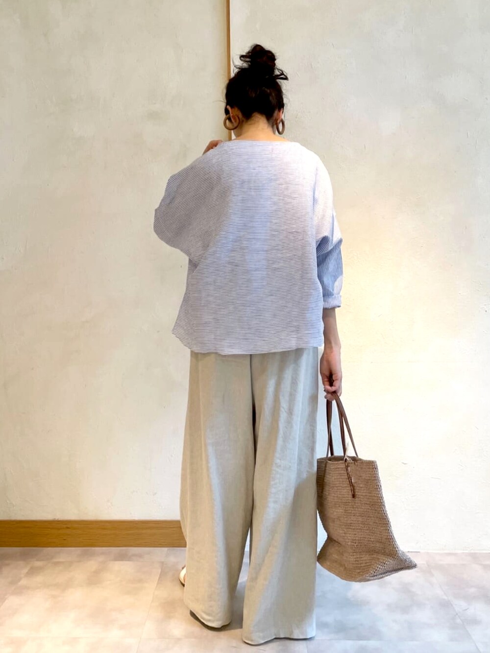 ブルー系のシャツ/ブラウス、ベージュ系のその他パンツ、ベージュ系のかごバッグを着用したレディースの春コーディネートの3枚目の写真