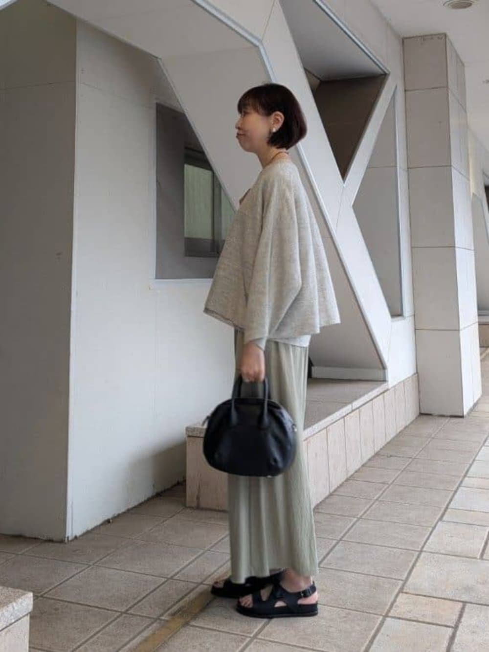 グリーン系のその他パンツ、ブラック系のサンダル、グレー系のニット/セーターを着用したレディースの冬コーディネートの2枚目の写真