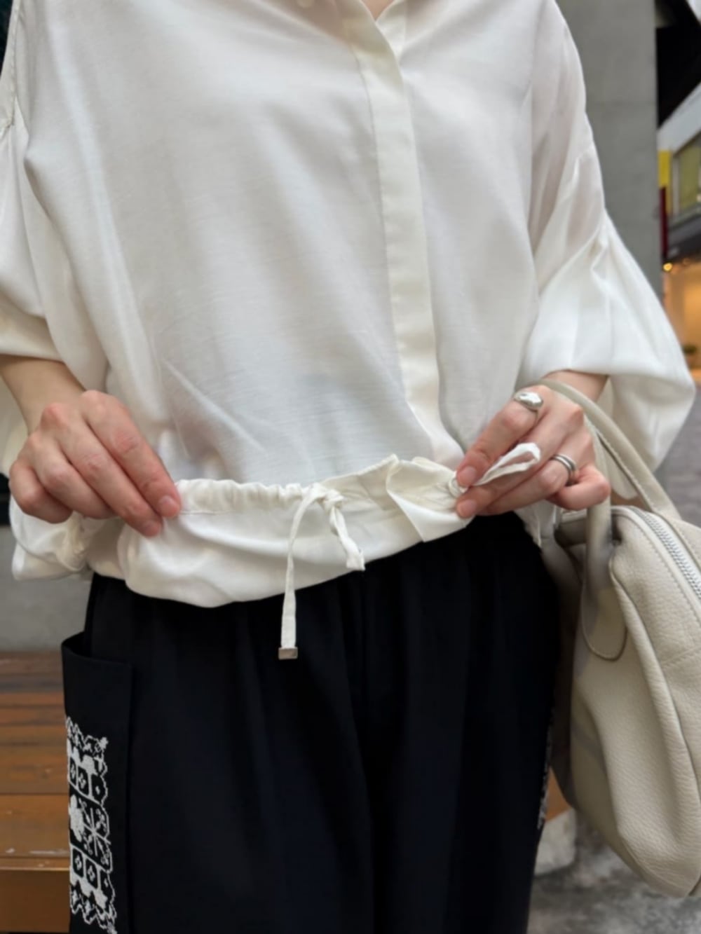 ホワイト系のシャツ/ブラウス、ブラック系のその他パンツ、ブラック系のブーツを着用したレディースの秋コーディネートの8枚目の写真