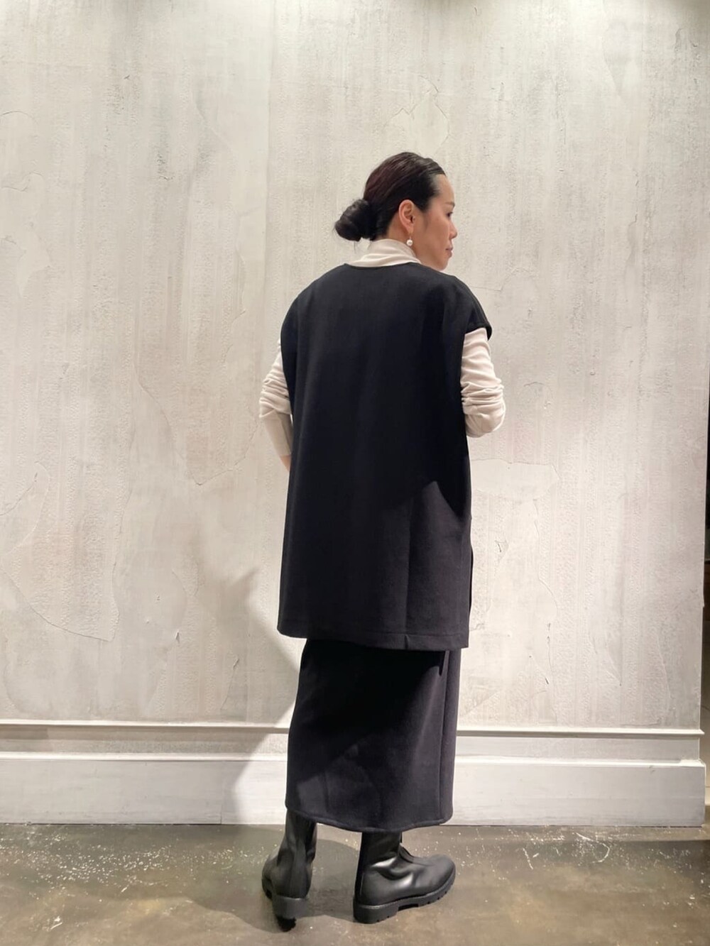 ブラック系のTシャツ/カットソー、ブラック系のスカート、ベージュ系のTシャツ/カットソーを着用したレディースの秋コーディネートの3枚目の写真