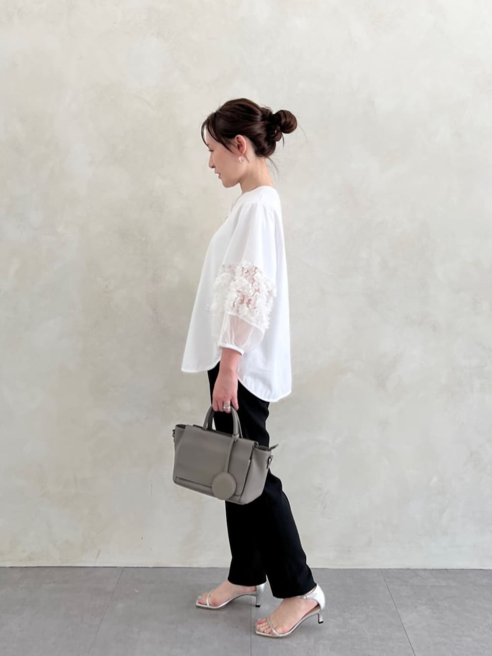 グレー系のハンドバッグ、ブラック系のその他パンツ、ホワイト系のTシャツ/カットソーを着用したレディースの春コーディネートの6枚目の写真