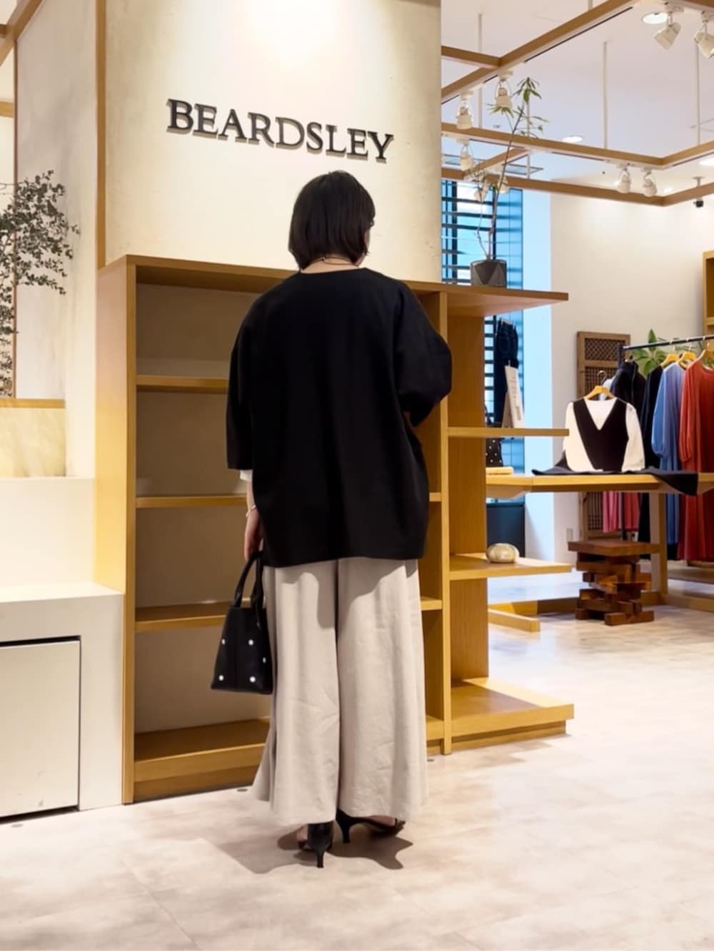 ブラック系のトートバッグ、ホワイト系のシャツ/ブラウス、グレー系のその他パンツを着用したレディースの春コーディネートの4枚目の写真