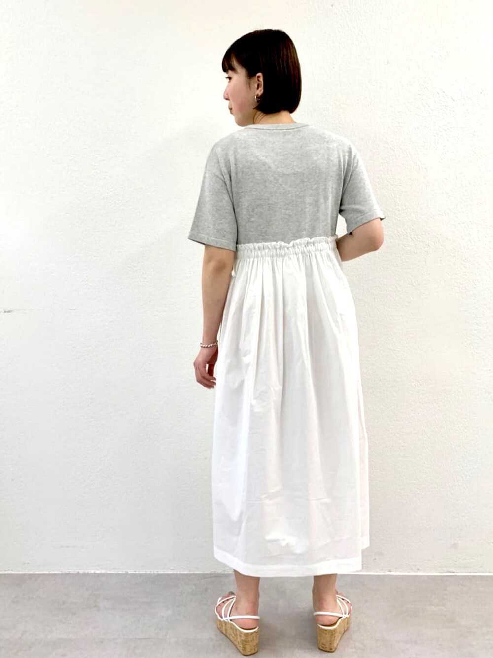 グレー系のワンピース、ホワイト系のその他シューズを着用したレディースの春コーディネートの3枚目の写真