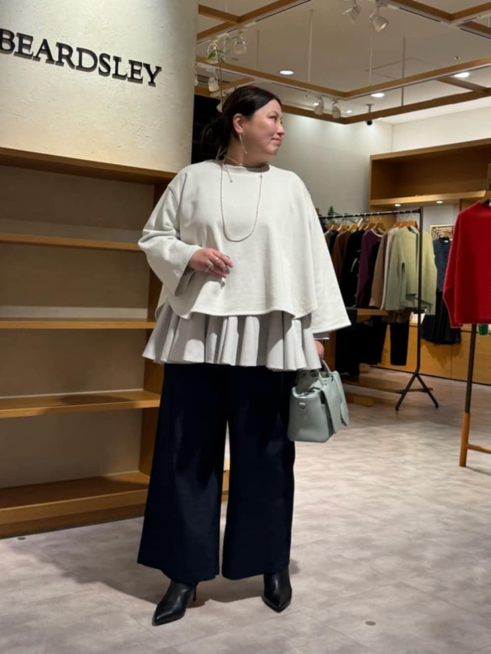 ブルー系のその他パンツ、グリーン系のハンドバッグ、ホワイト系のTシャツ/カットソーを着用したレディースの冬コーディネートの2枚目の写真