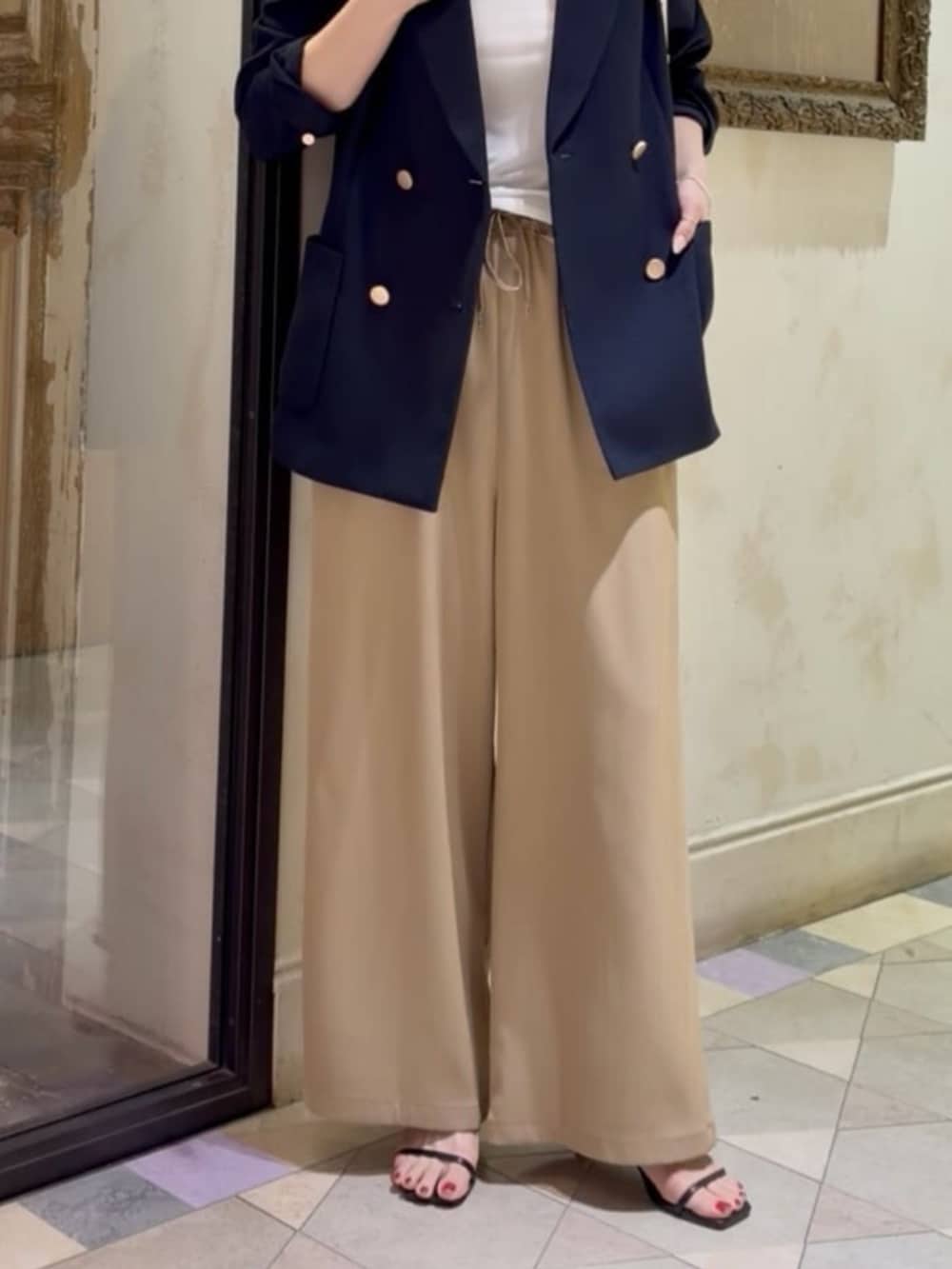 ブルー系のテーラードジャケット、ホワイト系のキャミソール、イエロー系のその他パンツを着用したレディースの春コーディネートの6枚目の写真