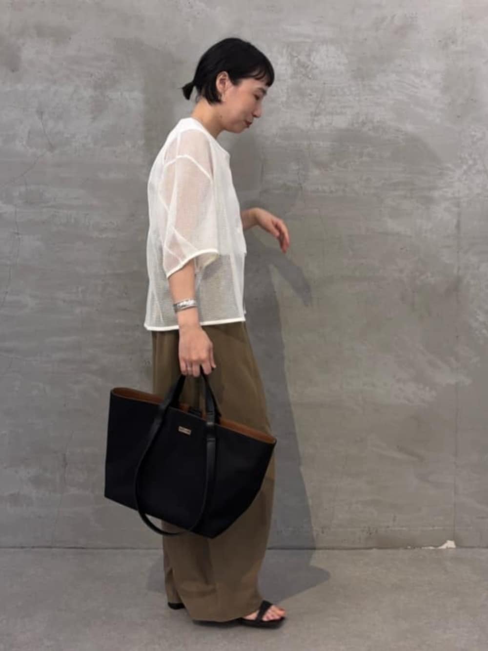 イエロー系のその他パンツ、ホワイト系のシャツ/ブラウス、ブラック系のトートバッグを着用したレディースの春コーディネートの4枚目の写真