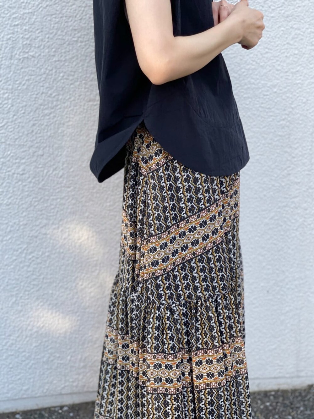 ブラック系のシャツ/ブラウス、ブラック系のスカート、シルバー系のサンダルを着用したレディースの夏コーディネートの4枚目の写真