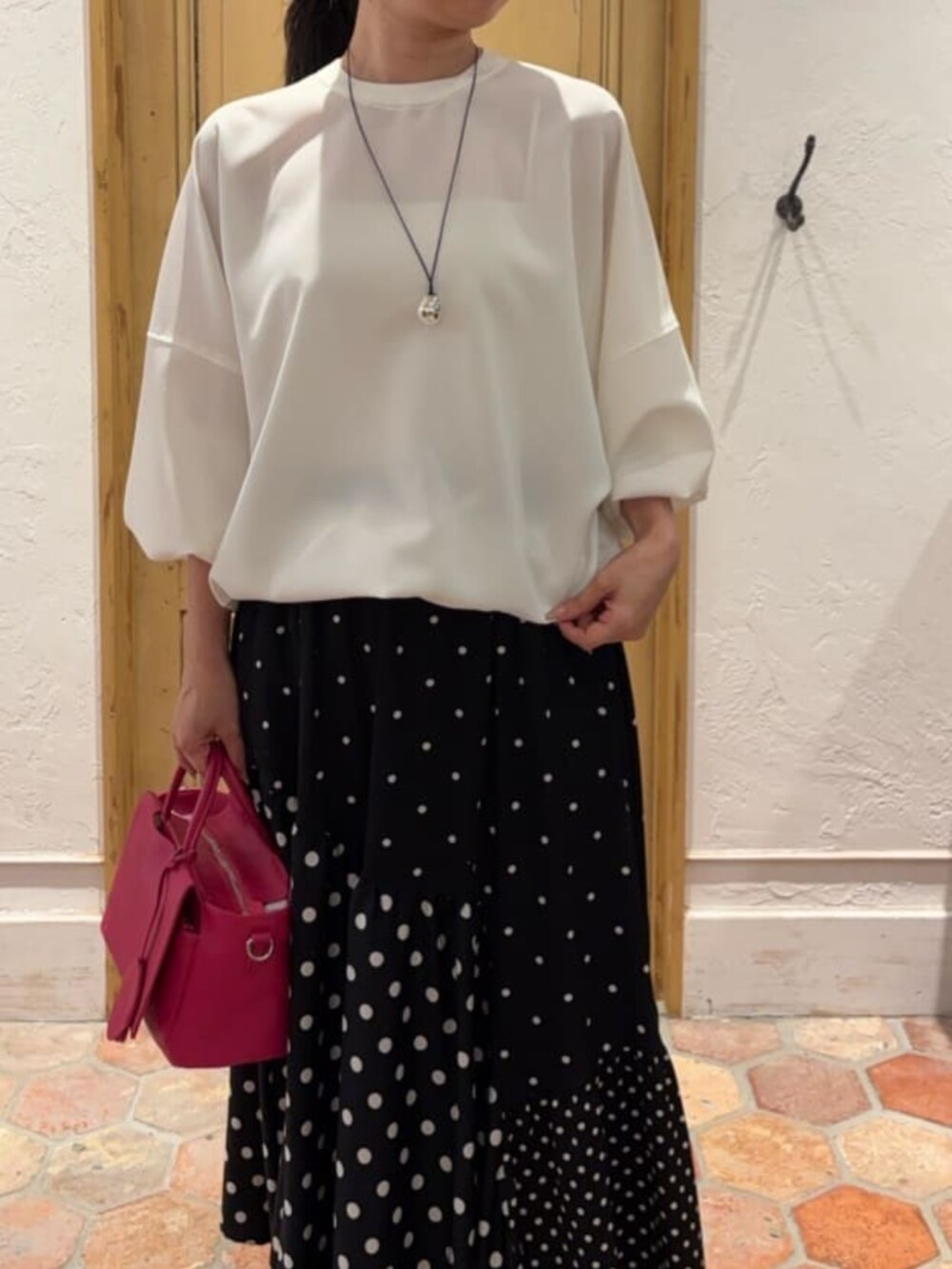 ブラック系のスカート、ピンク系のハンドバッグ、ホワイト系のシャツ/ブラウスを着用したレディースの冬コーディネートの6枚目の写真