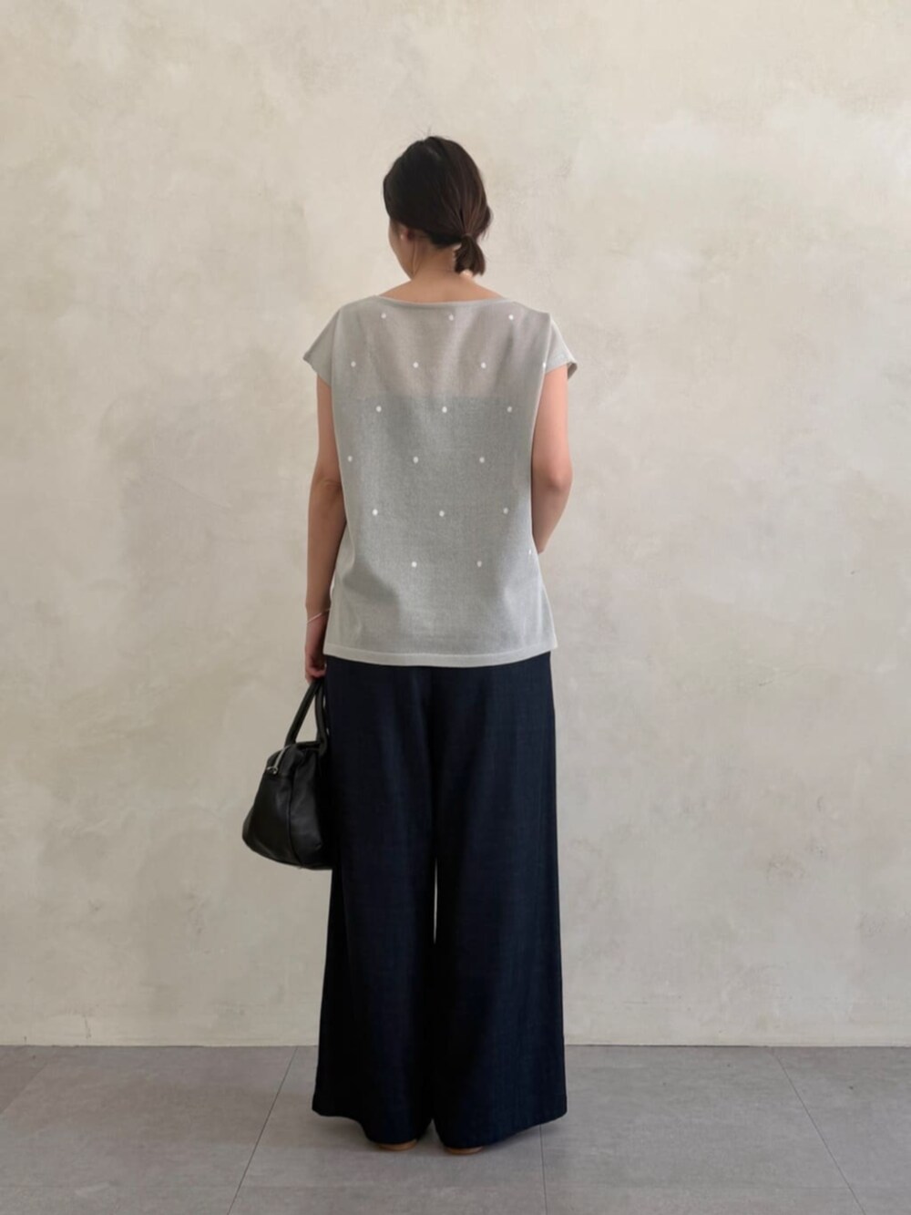ブルー系のその他パンツ、ブラック系のボストンバッグ、グレー系のニット/セーターを着用したレディースの春コーディネートの3枚目の写真