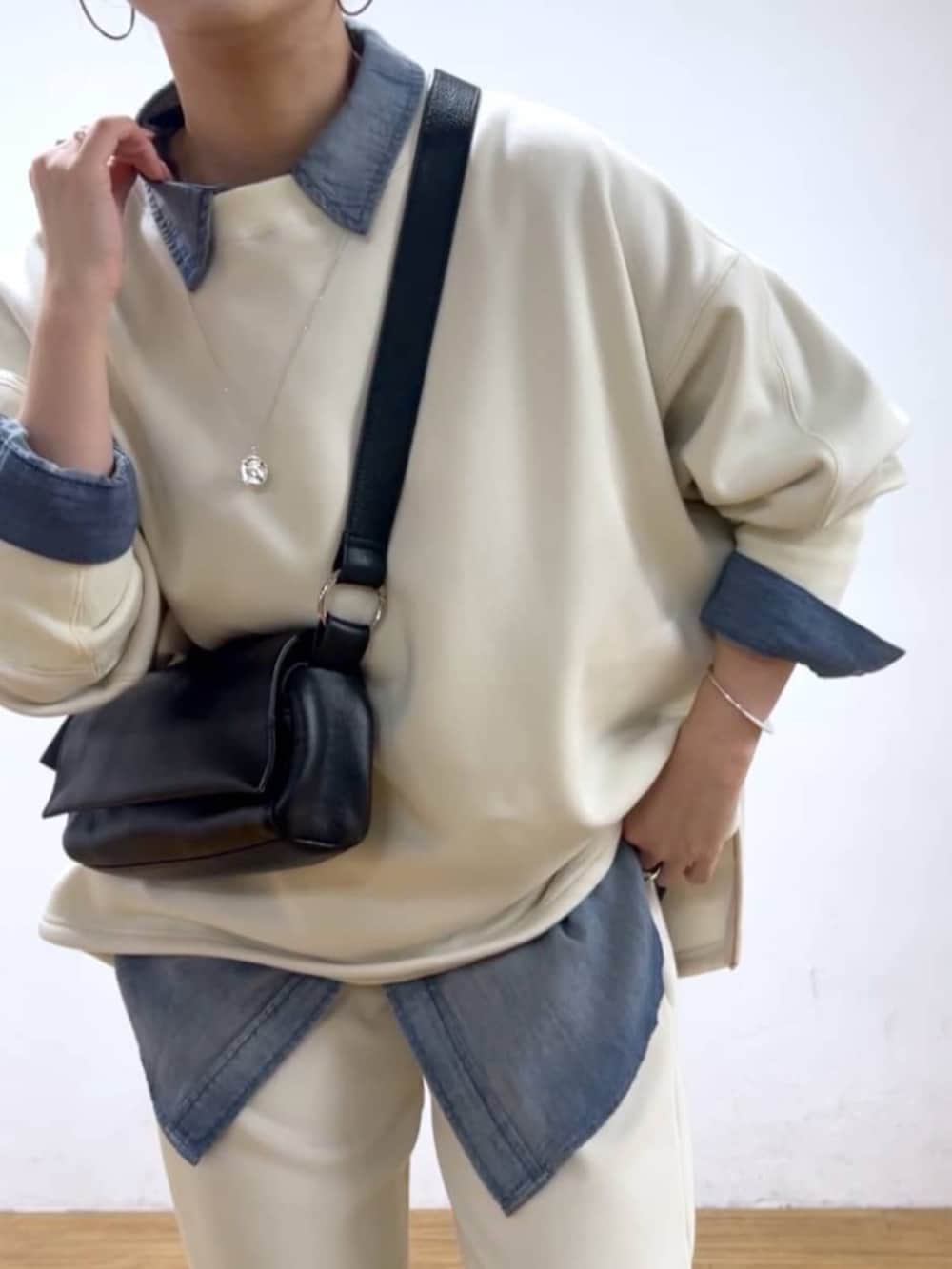 ブルー系のシャツ/ブラウス、ブラック系のショルダーバッグ、ホワイト系のTシャツ/カットソーを着用したレディースの秋コーディネートの3枚目の写真