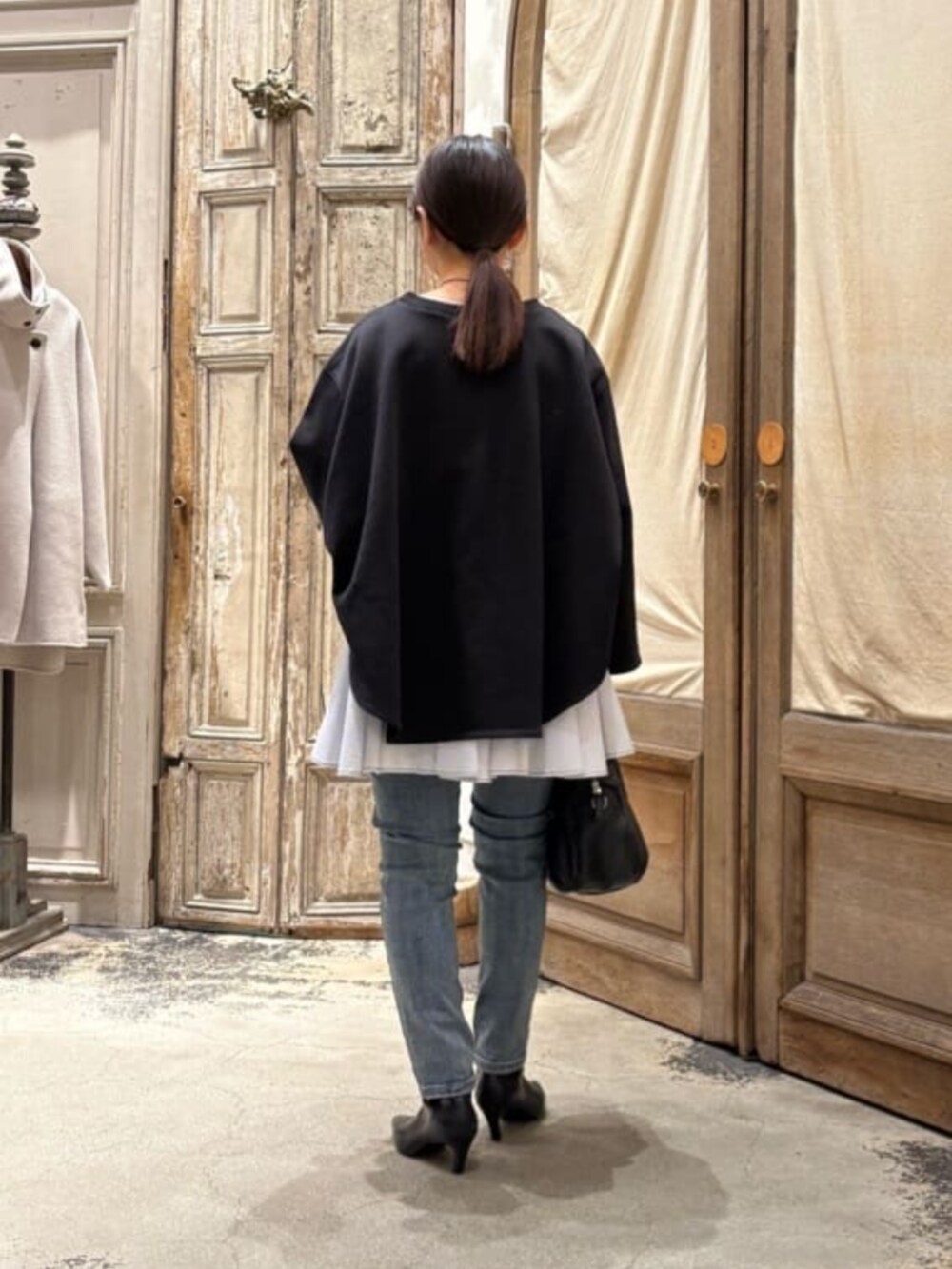 ブルー系のデニムパンツ、ブラック系のボストンバッグ、ブラック系のTシャツ/カットソーを着用したレディースの冬コーディネートの6枚目の写真