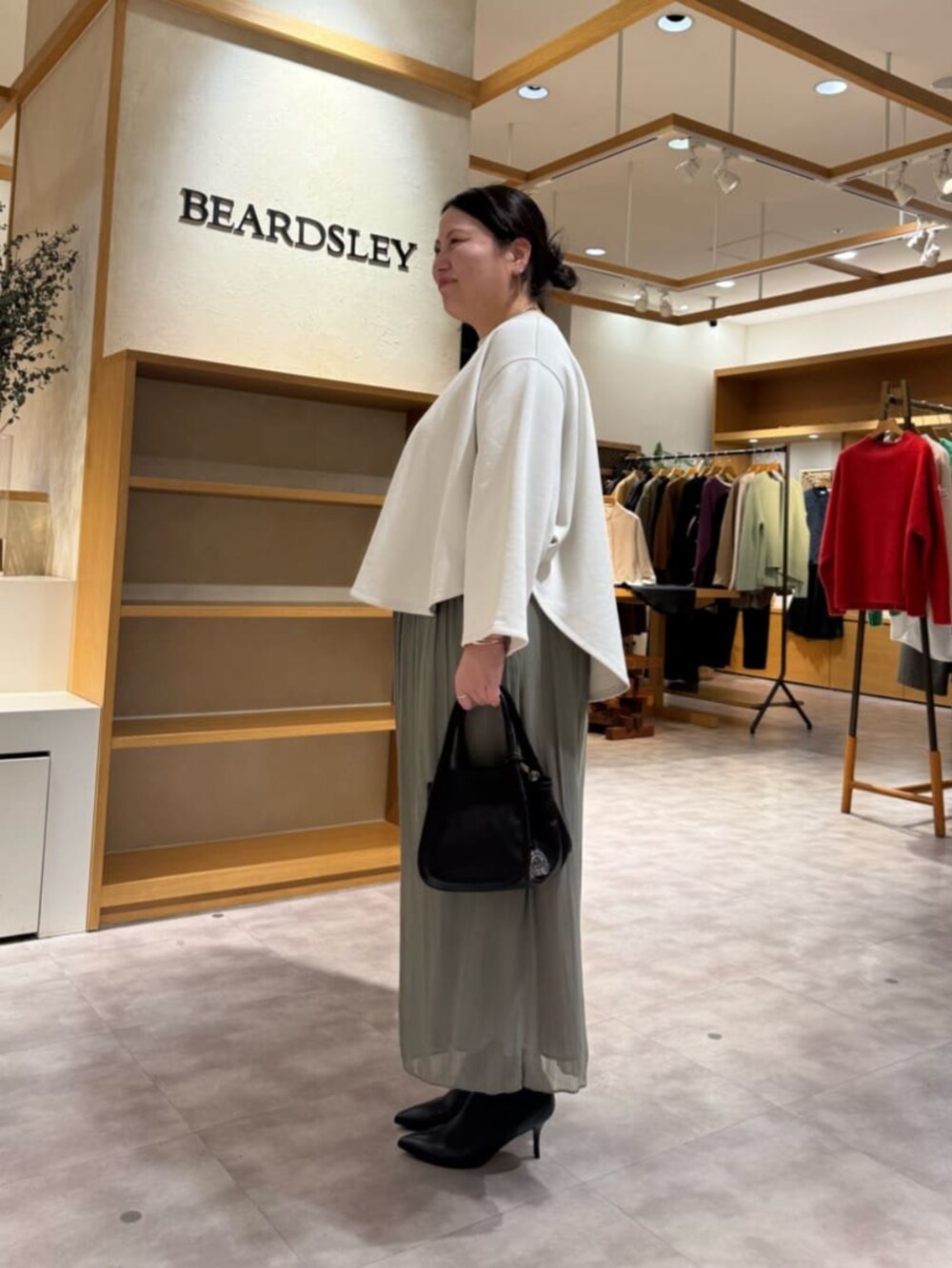 グリーン系のその他パンツ、ブラック系のブーツ、ブラック系のトートバッグを着用したレディースの冬コーディネートの2枚目の写真