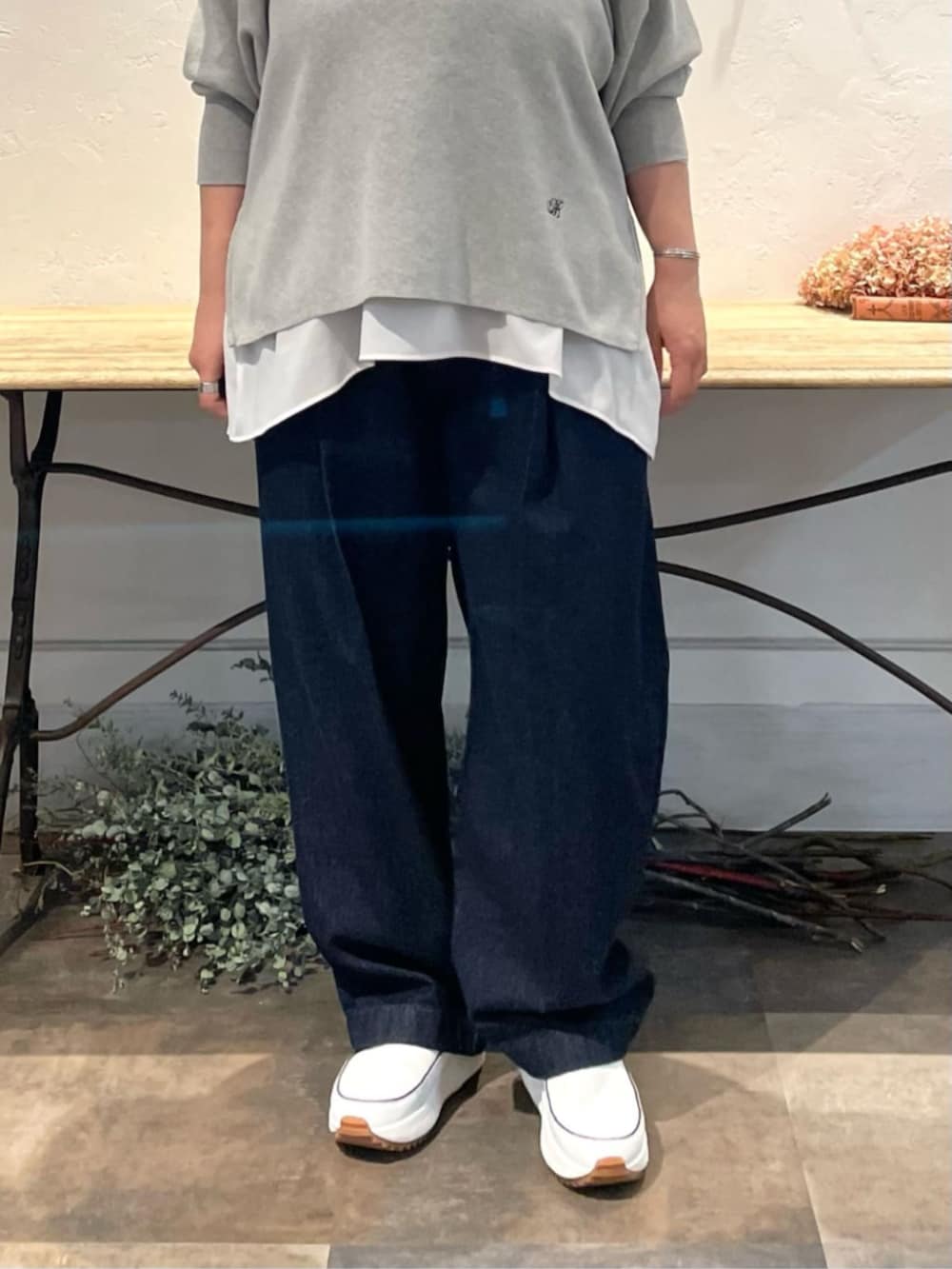 ホワイト系のスニーカー、ホワイト系のシャツ/ブラウス、グレー系のニット/セーターを着用したレディースの冬コーディネートの6枚目の写真