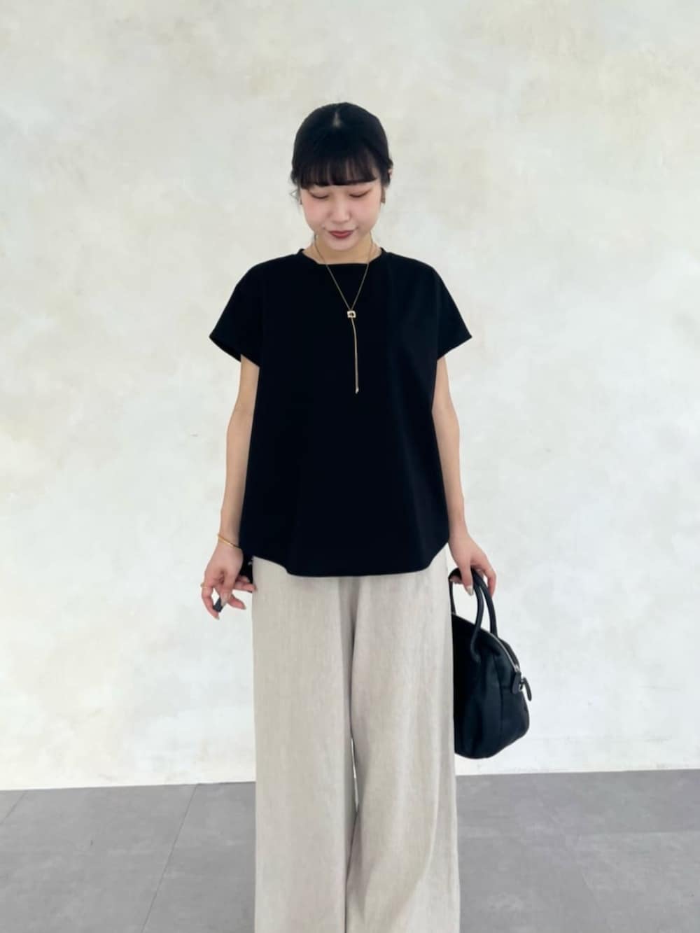 ベージュ系のその他パンツ、ブラック系のTシャツ/カットソー、ブラック系のサンダルを着用したレディースの春コーディネートの5枚目の写真