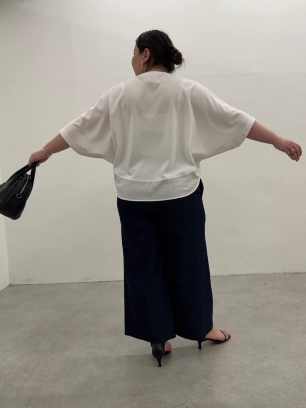 ブラック系のボストンバッグ、ブルー系のその他パンツ、ホワイト系のTシャツ/カットソーを着用したレディースの春コーディネートの7枚目の写真