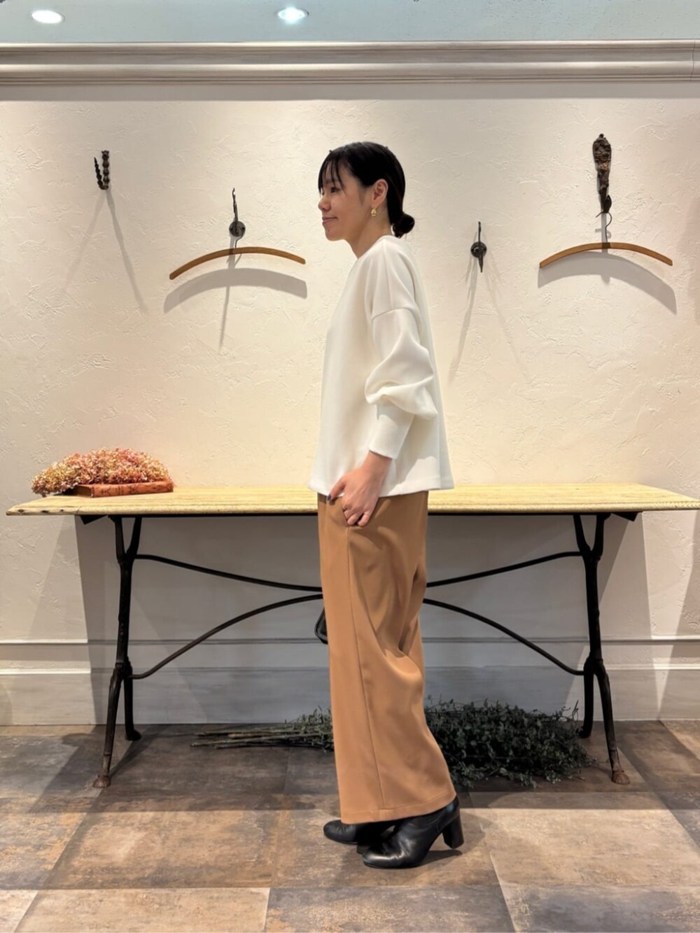 イエロー系のその他パンツ、ブラック系のトートバッグ、ホワイト系のTシャツ/カットソーを着用したレディースの冬コーディネートの6枚目の写真