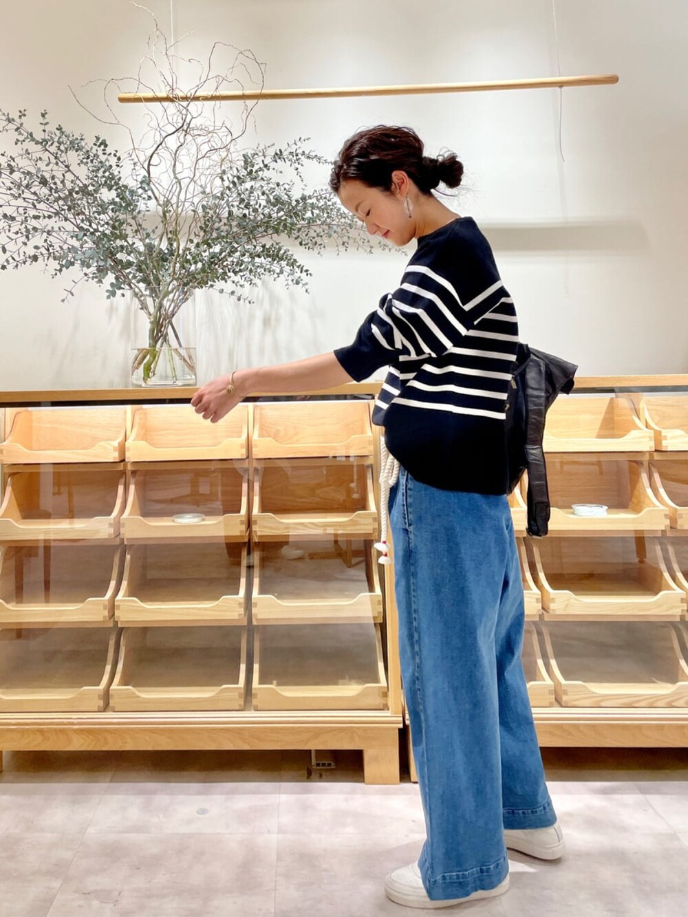 ブラック系のブルゾン、ブルー系のデニムパンツ、ブルー系のニット/セーターを着用したレディースの冬コーディネートの2枚目の写真