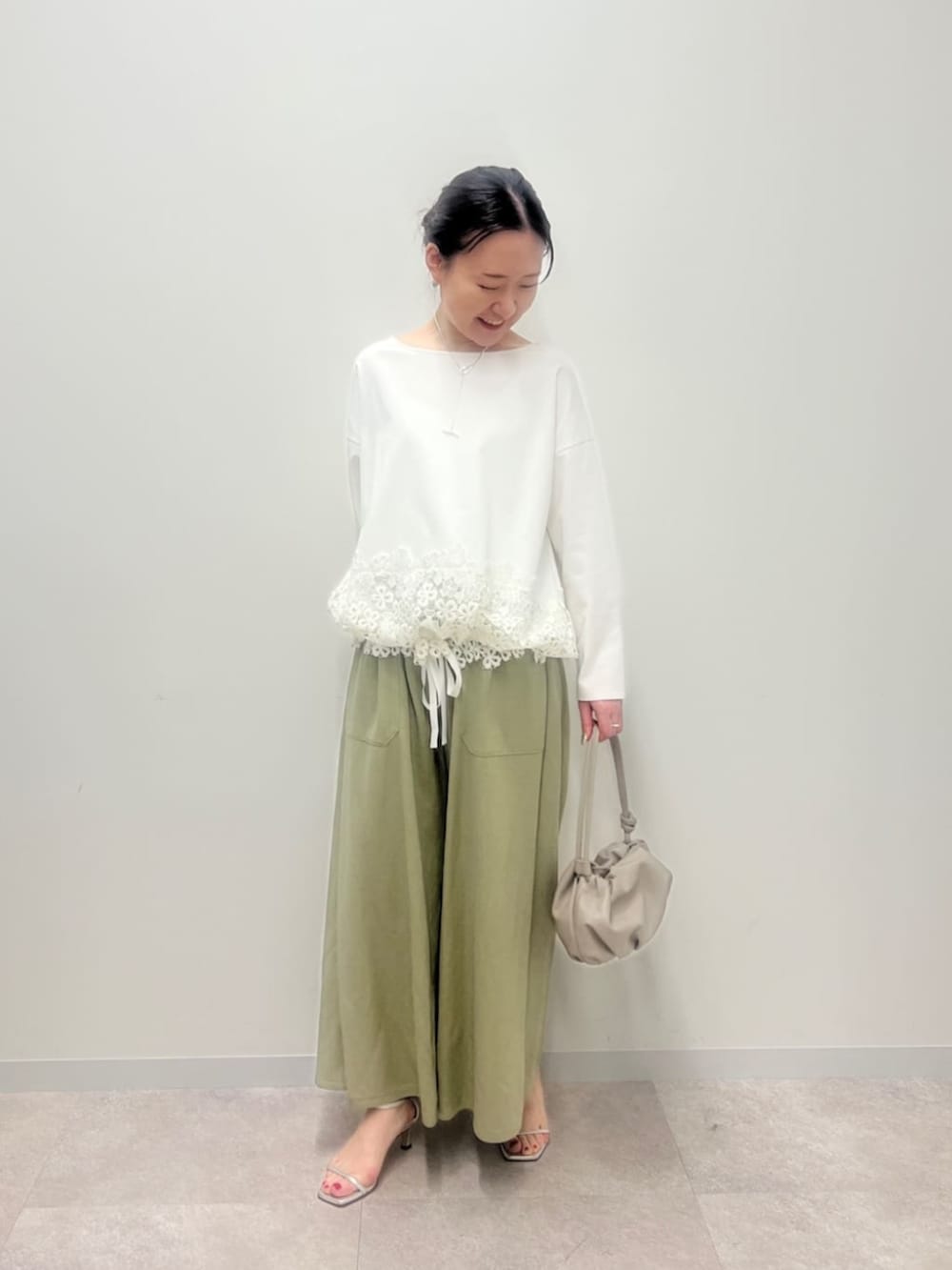 ベージュ系のショルダーバッグ、グリーン系のその他パンツ、ホワイト系のTシャツ/カットソーを着用したレディースの冬コーディネートの2枚目の写真