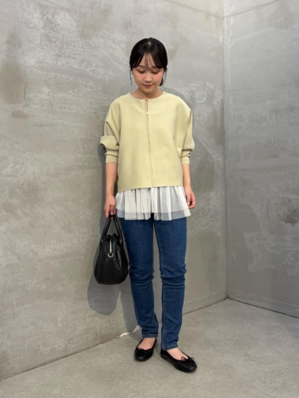 ホワイト系のキャミソール、ブルー系のデニムパンツ、ベージュ系のカーディガン/ボレロを着用したレディースの秋コーディネートの2枚目の写真