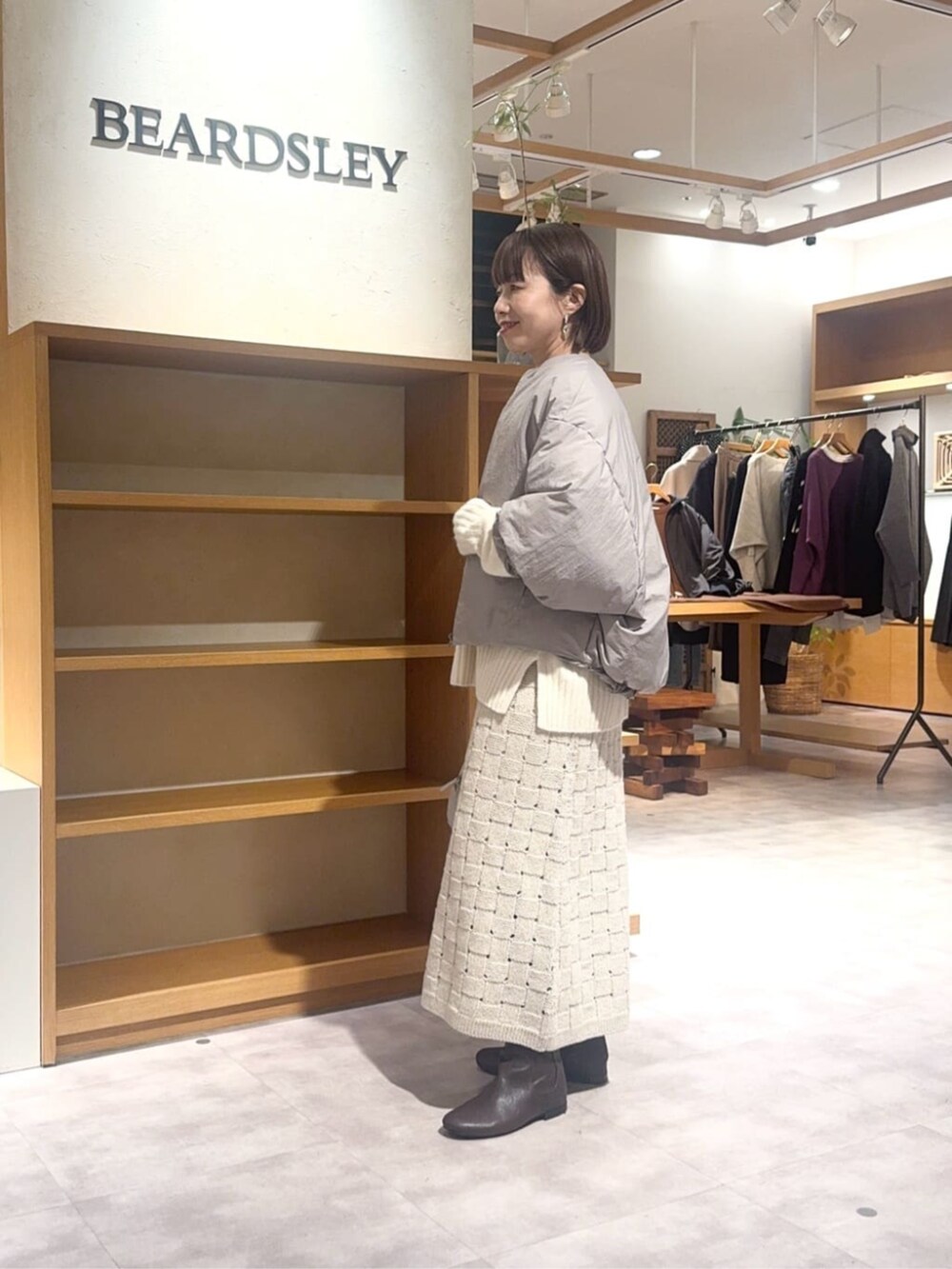 グレー系のボストンバッグ、ベージュ系のスカート、ブラウン系のダウンジャケット/コートを着用したレディースの冬コーディネートの5枚目の写真