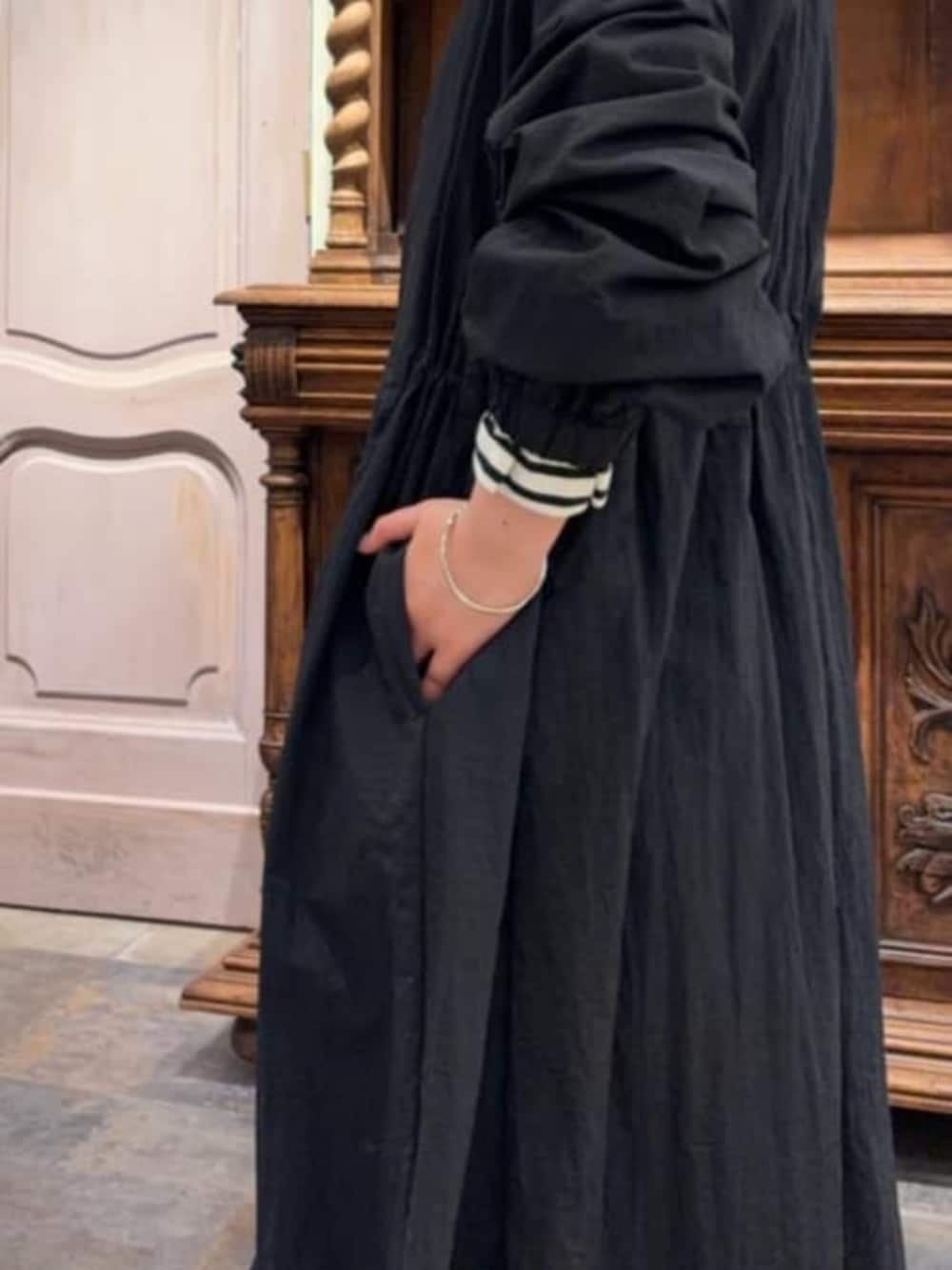 ブラック系のその他アウター、ベージュ系のショルダーバッグ、ブルー系のデニムパンツを着用したレディースの冬コーディネートの5枚目の写真