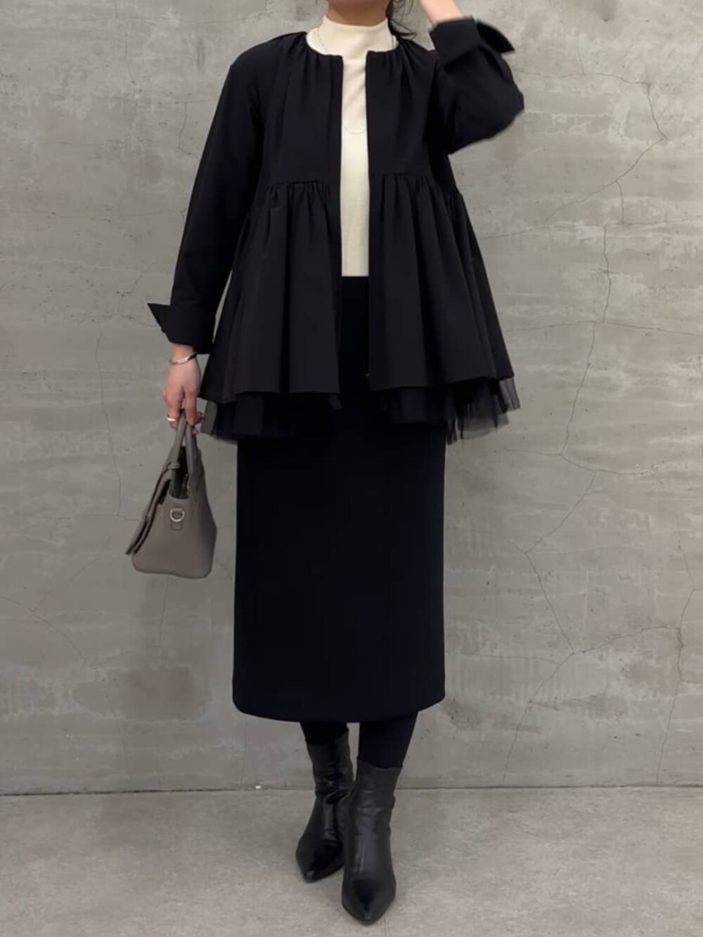 ブラック系のスカート、ブラック系のブルゾンを着用したレディースの冬コーディネートの2枚目の写真