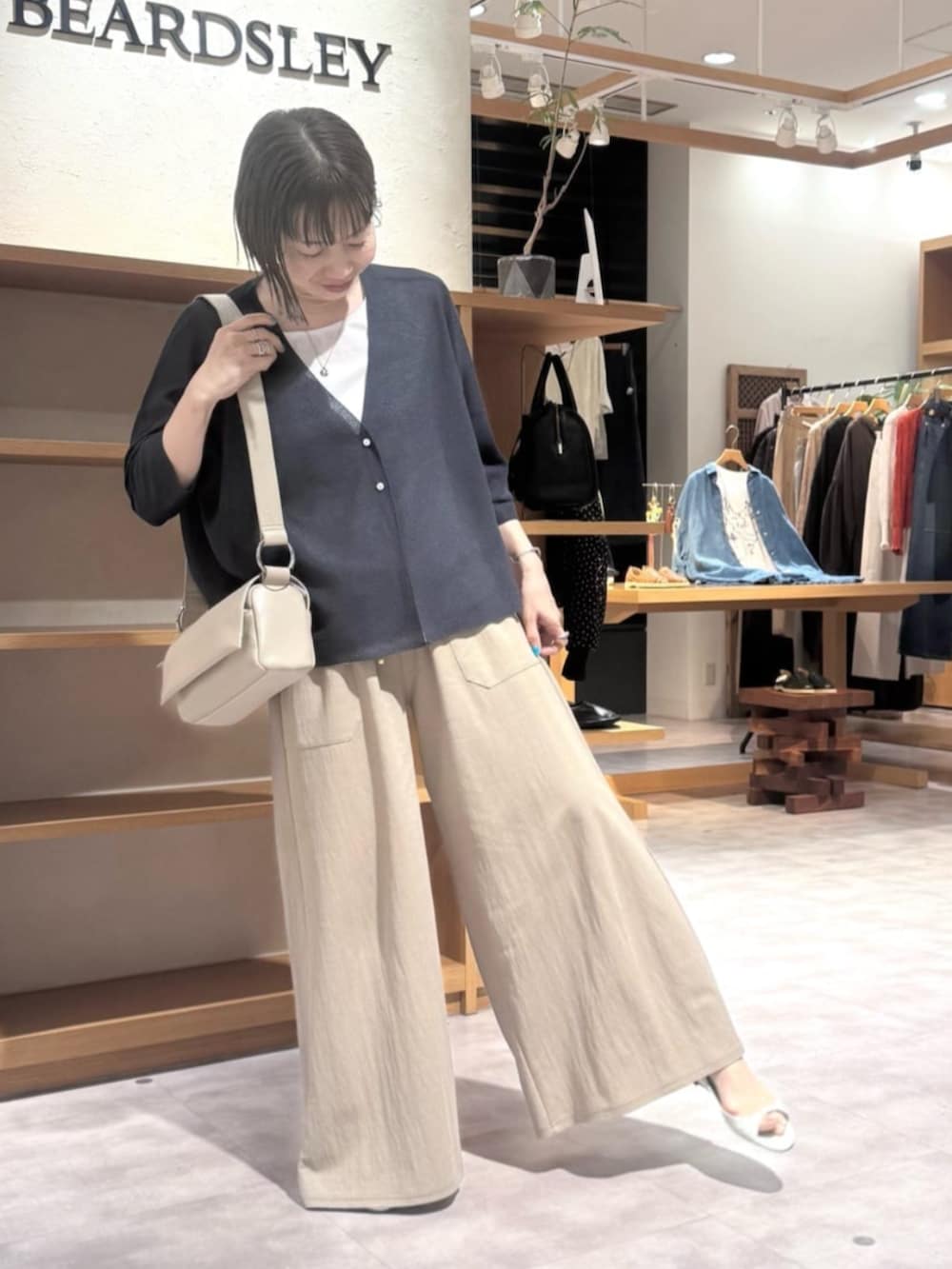 ベージュ系のその他パンツ、ベージュ系のショルダーバッグ、ブルー系のカーディガン/ボレロを着用したレディースの夏コーディネートの4枚目の写真