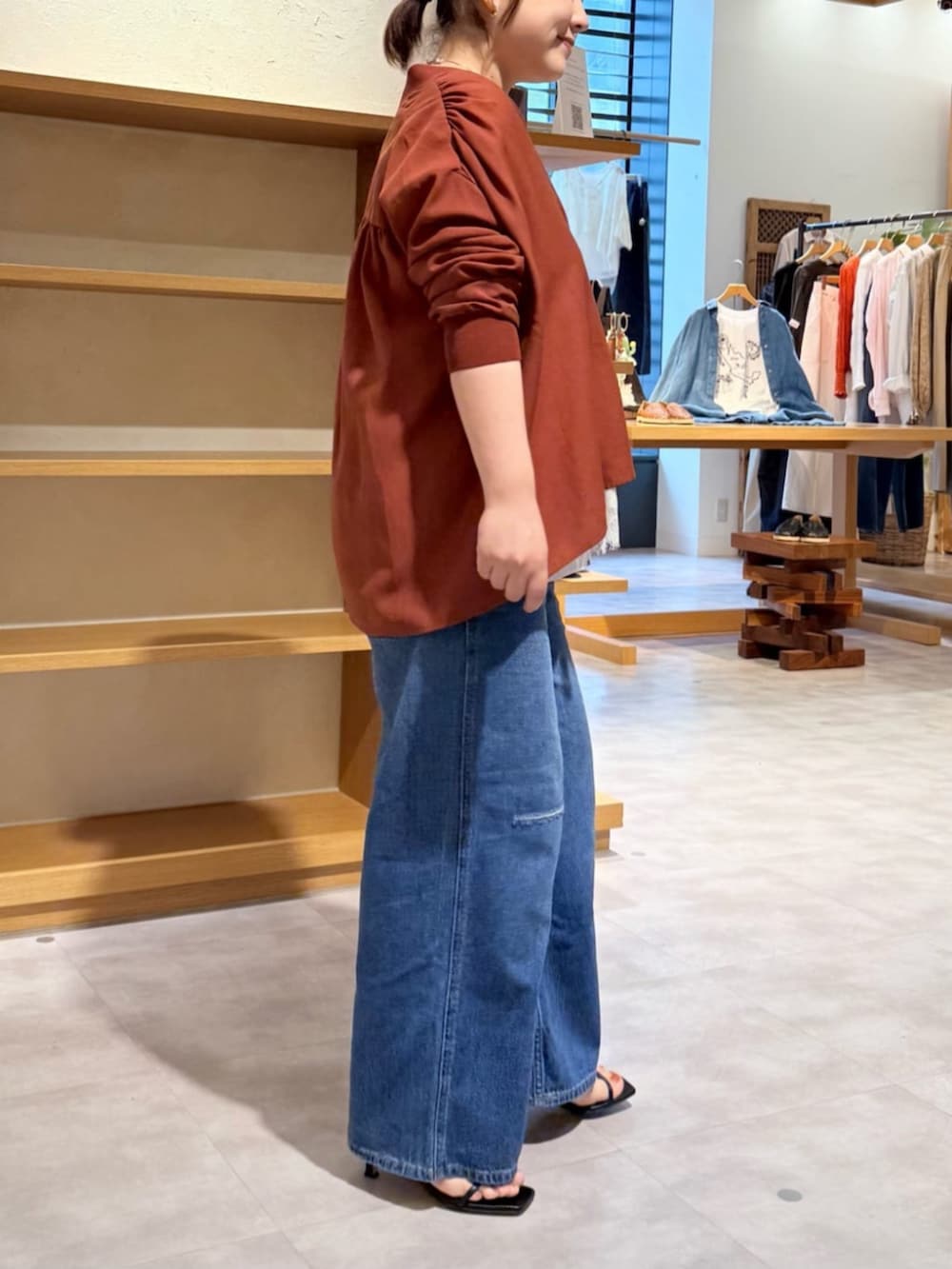 ベージュ系のショルダーバッグ、ブルー系のその他パンツ、レッド系のシャツ/ブラウスを着用したレディースの春コーディネートの3枚目の写真