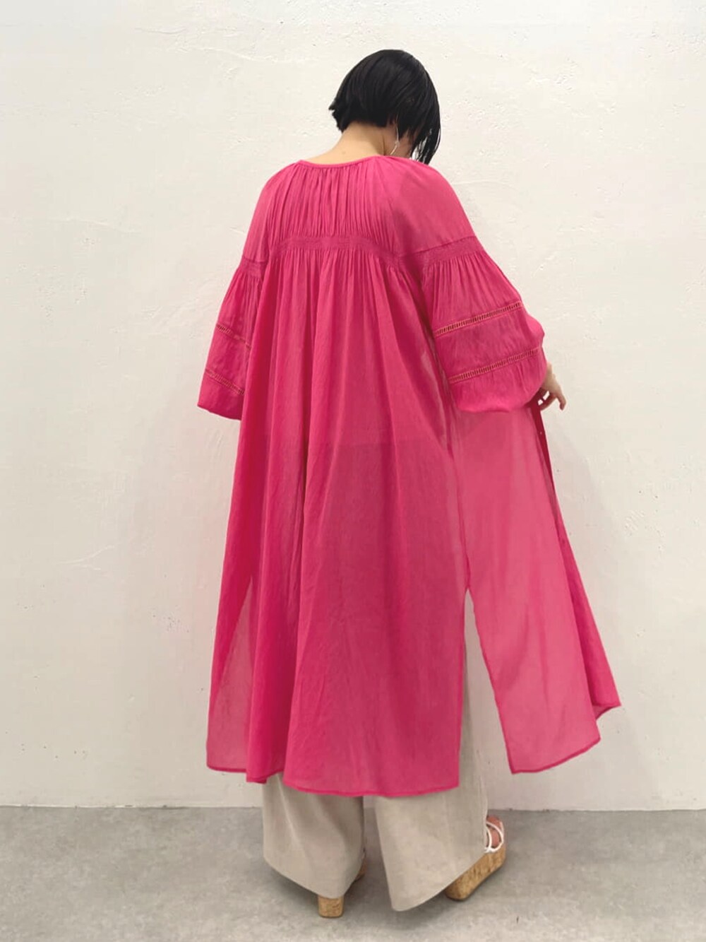 ピンク系のワンピース、ベージュ系のTシャツ/カットソー、グリーン系のその他パンツを着用したレディースの春コーディネートの2枚目の写真