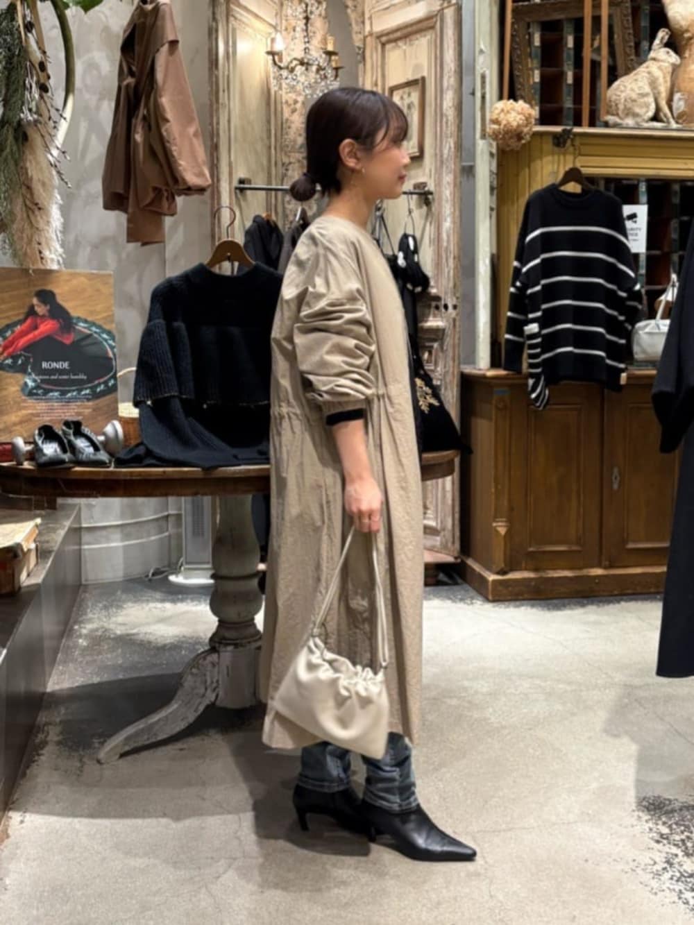 ベージュ系のその他アウター、ブルー系のデニムパンツを着用したレディースの冬コーディネートの2枚目の写真