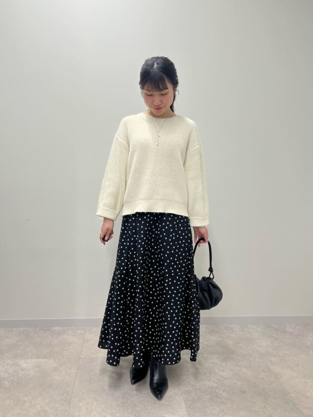 ブラック系のスカート、ホワイト系のニット/セーターを着用したレディースの冬コーディネートの3枚目の写真