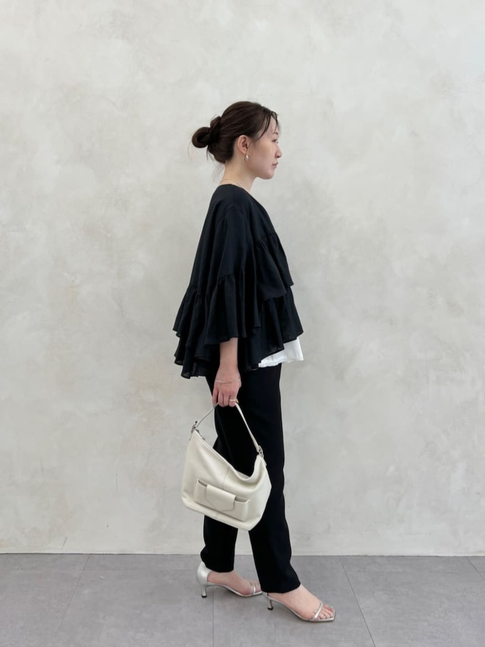 ホワイト系のトートバッグ、ブラック系のその他パンツ、ホワイト系のシャツ/ブラウスを着用したレディースの春コーディネートの2枚目の写真