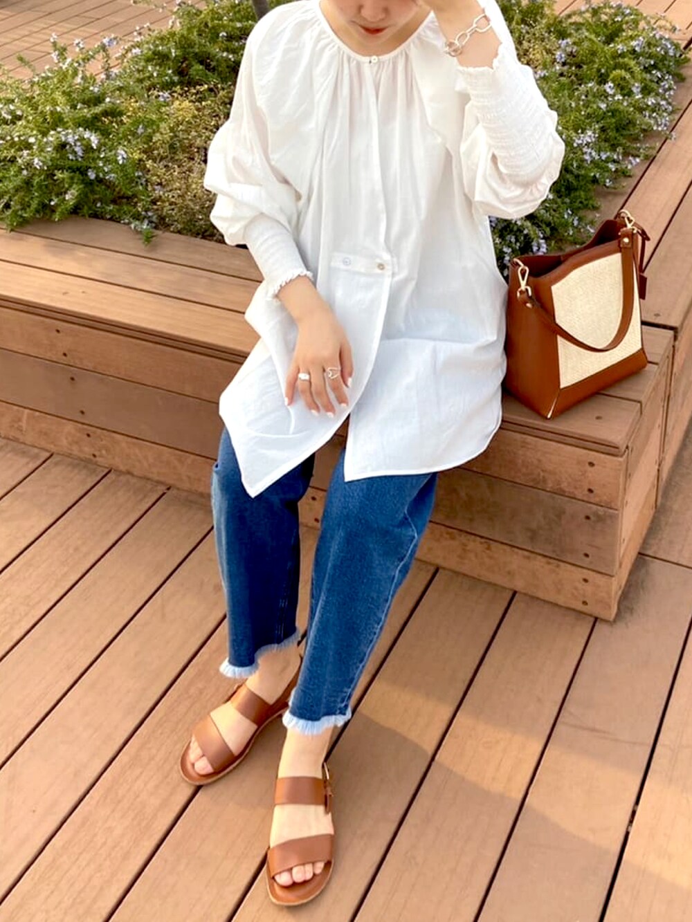 ホワイト系のシャツ/ブラウス、ブルー系のデニムパンツ、ベージュ系のトートバッグを着用したレディースの春コーディネートの2枚目の写真