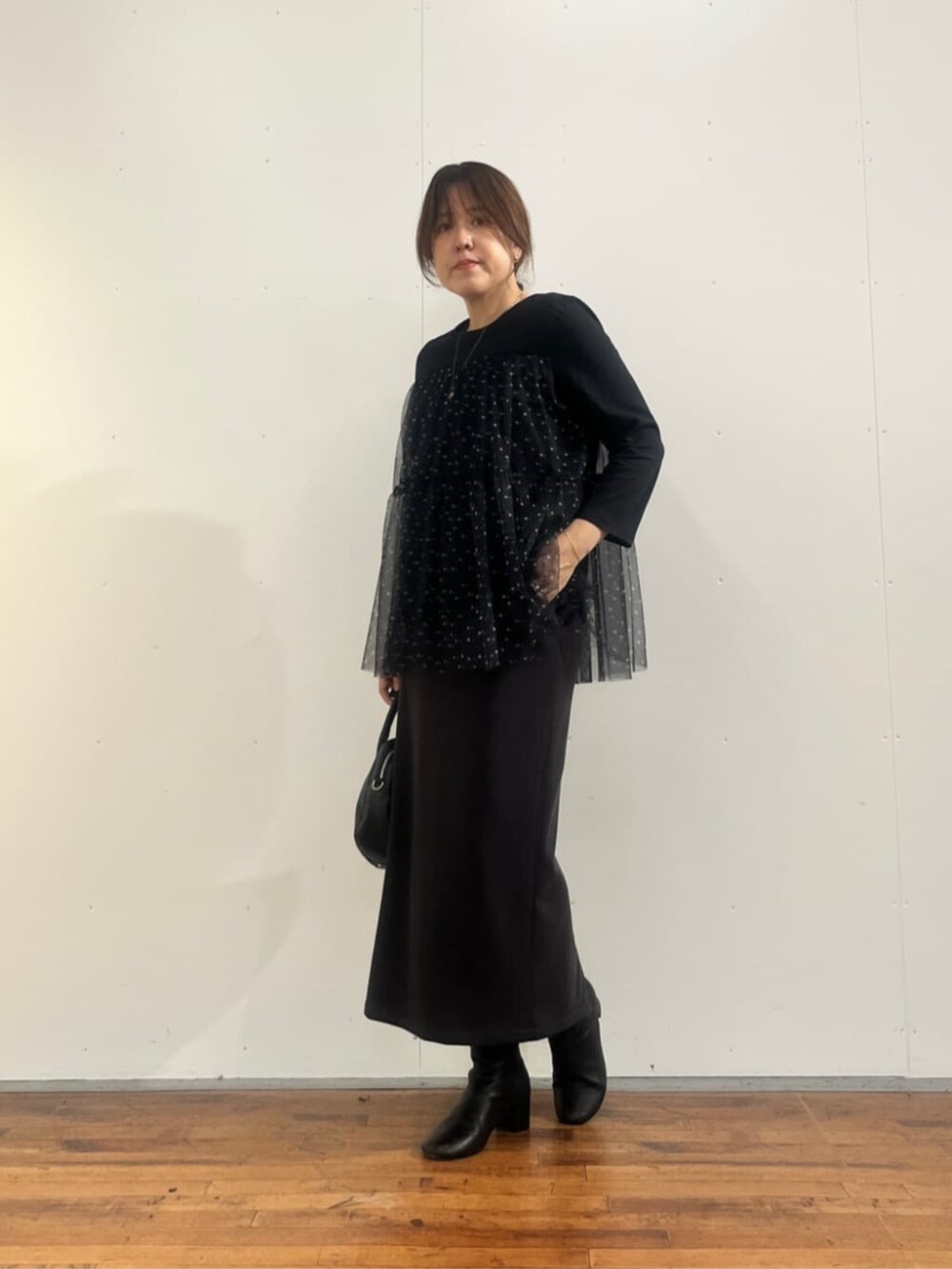 ブラック系のボストンバッグ、グレー系のスカート、ブラック系のTシャツ/カットソーを着用したレディースの夏コーディネートの5枚目の写真