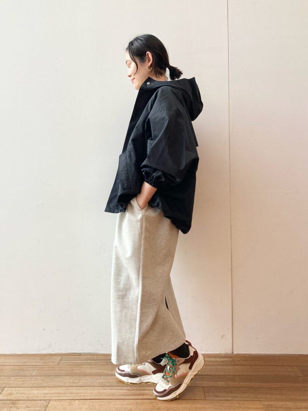 ブラック系のマウンテンパーカー、グレー系のワンピース、ブラウン系のスニーカーを着用したレディースの春コーディネートの2枚目の写真