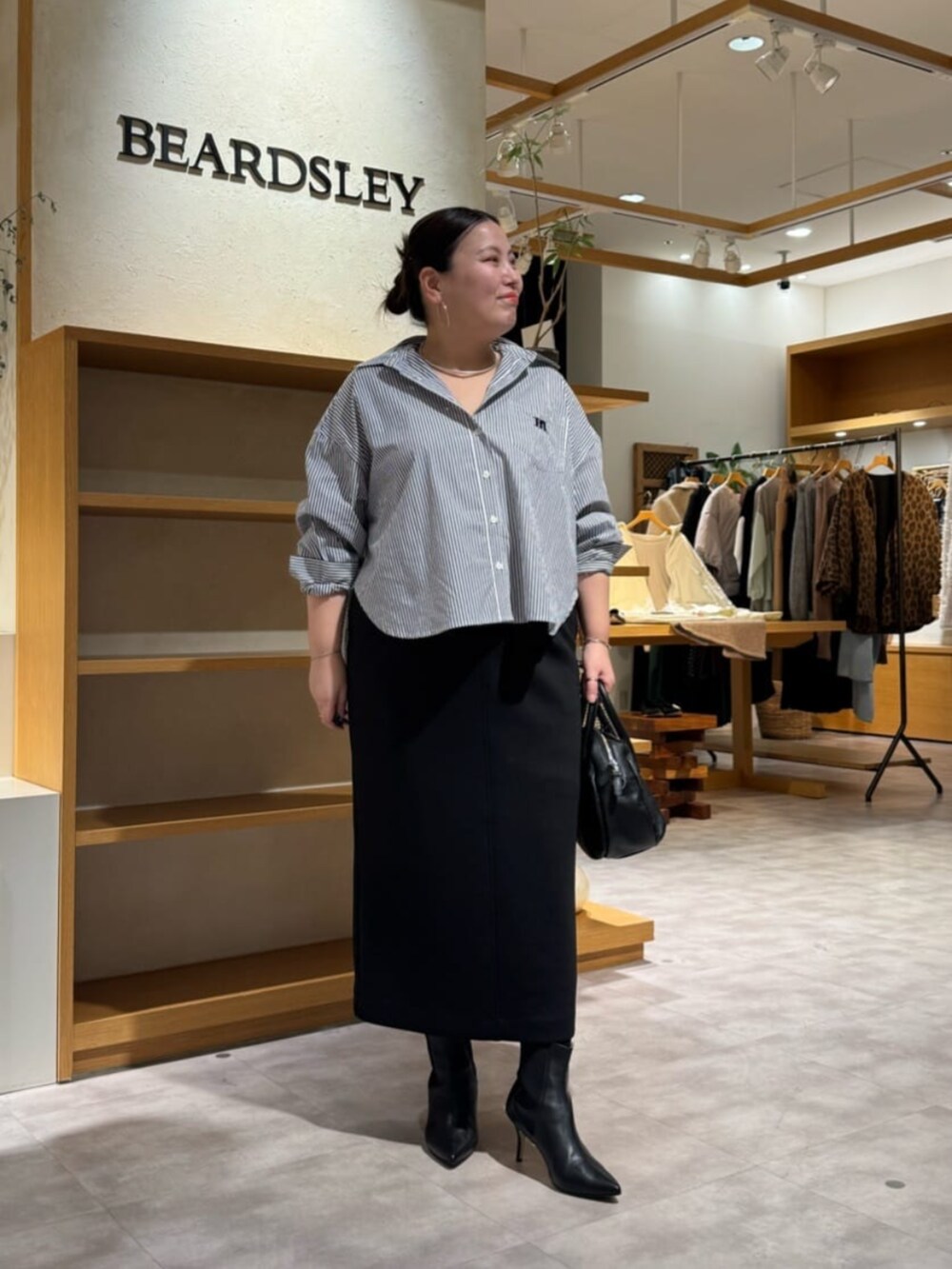 ブラック系のブーツ、ブルー系のシャツ/ブラウスを着用したレディースの冬コーディネートの3枚目の写真