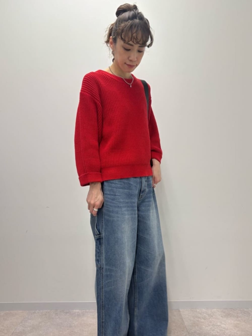 レッド系のニット/セーターを着用したレディースの冬コーディネートの3枚目の写真