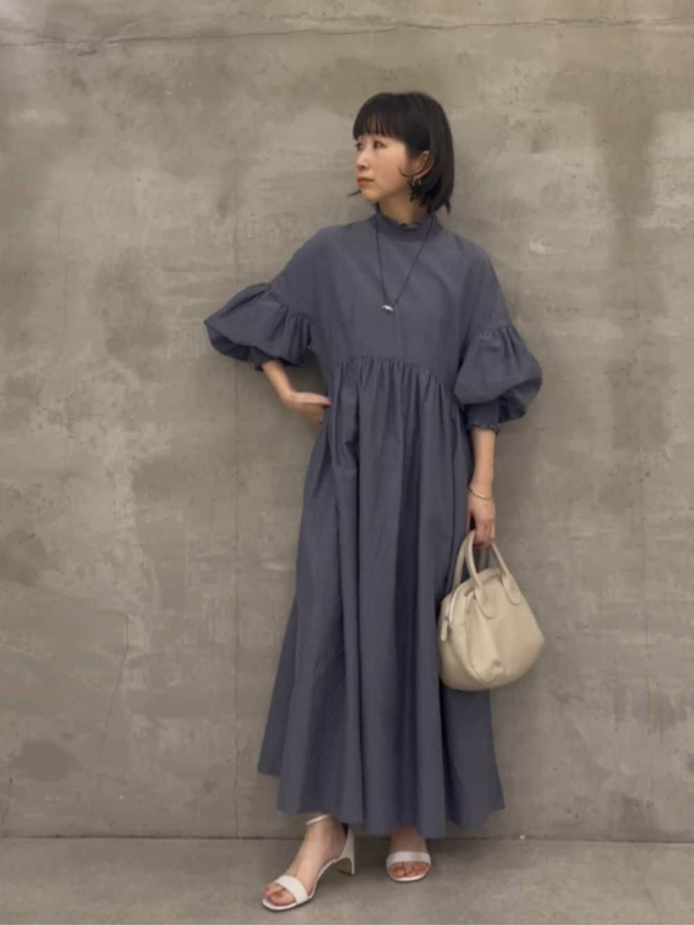 グレー系のボストンバッグ、グレー系のワンピースを着用したレディースの冬コーディネートの2枚目の写真