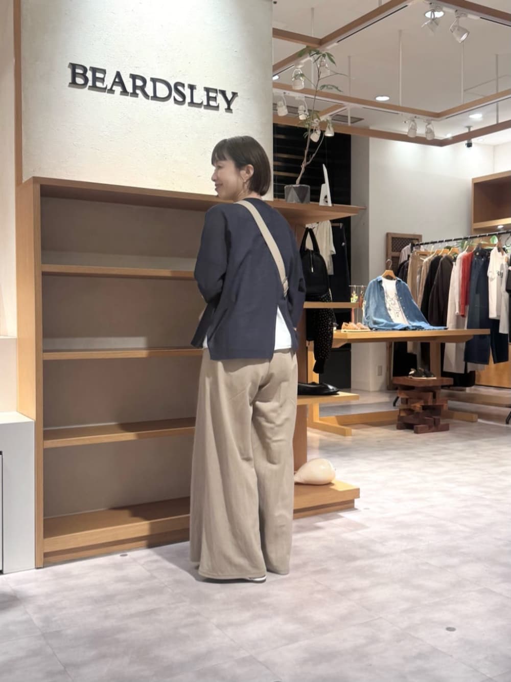 ベージュ系のその他パンツ、ベージュ系のショルダーバッグ、ブルー系のカーディガン/ボレロを着用したレディースの春コーディネートの4枚目の写真
