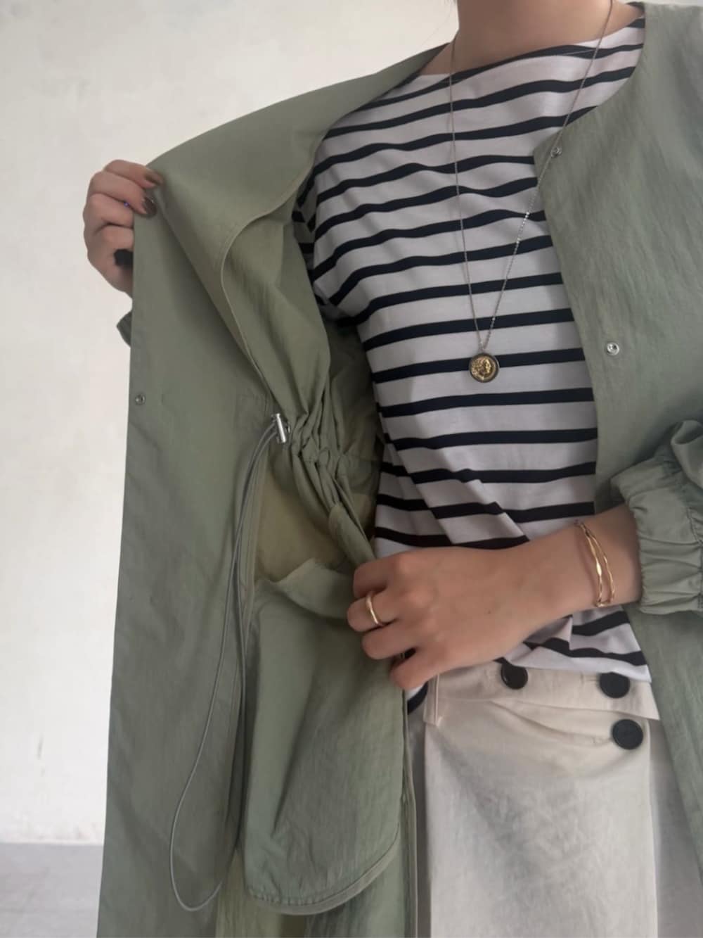 グリーン系のその他アウター、ホワイト系のその他パンツ、ホワイト系のTシャツ/カットソーを着用したレディースの冬コーディネートの5枚目の写真