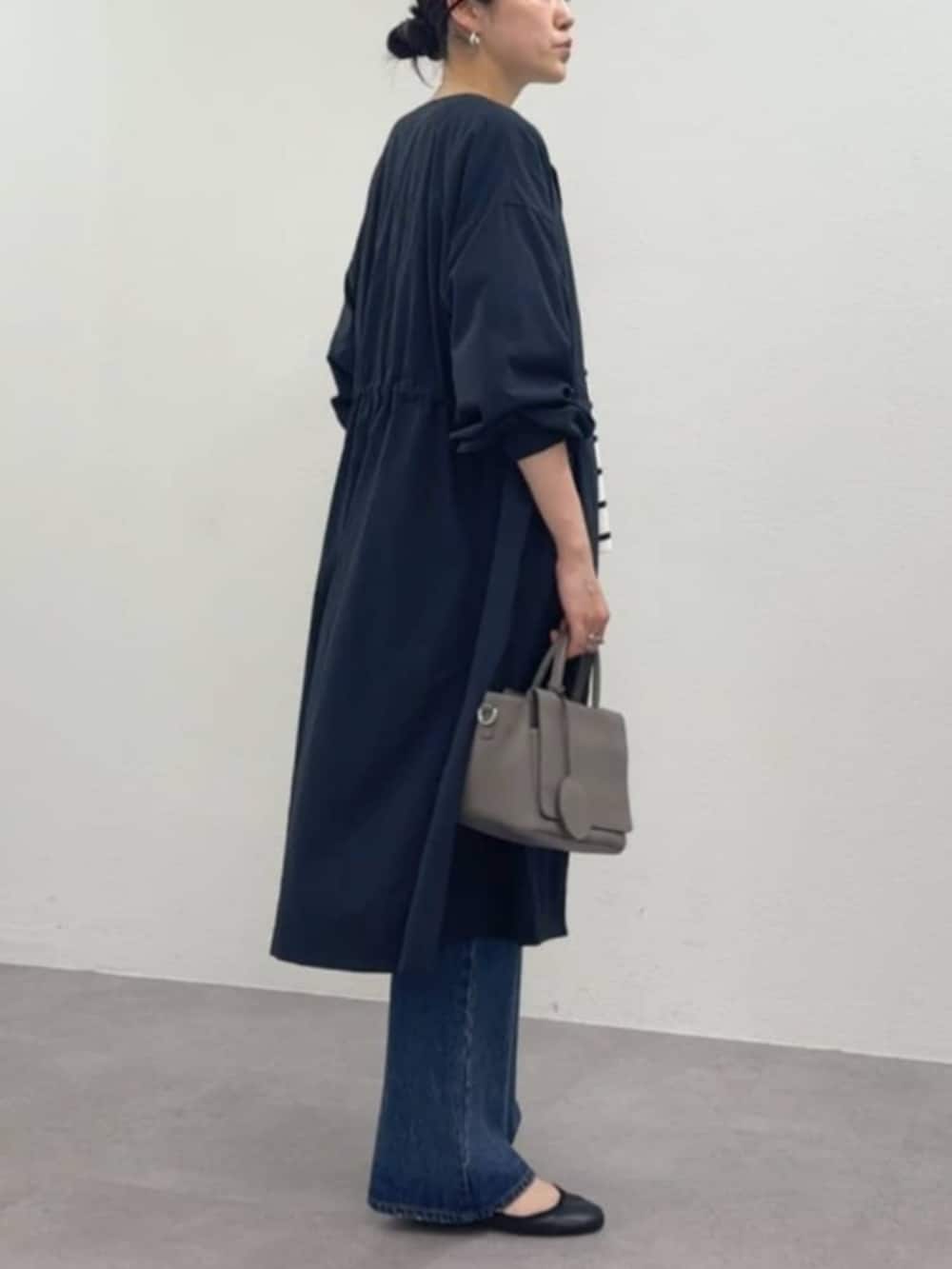 グレー系のハンドバッグ、ホワイト系のタンクトップ、ブルー系のその他アウターを着用したレディースの冬コーディネートの2枚目の写真