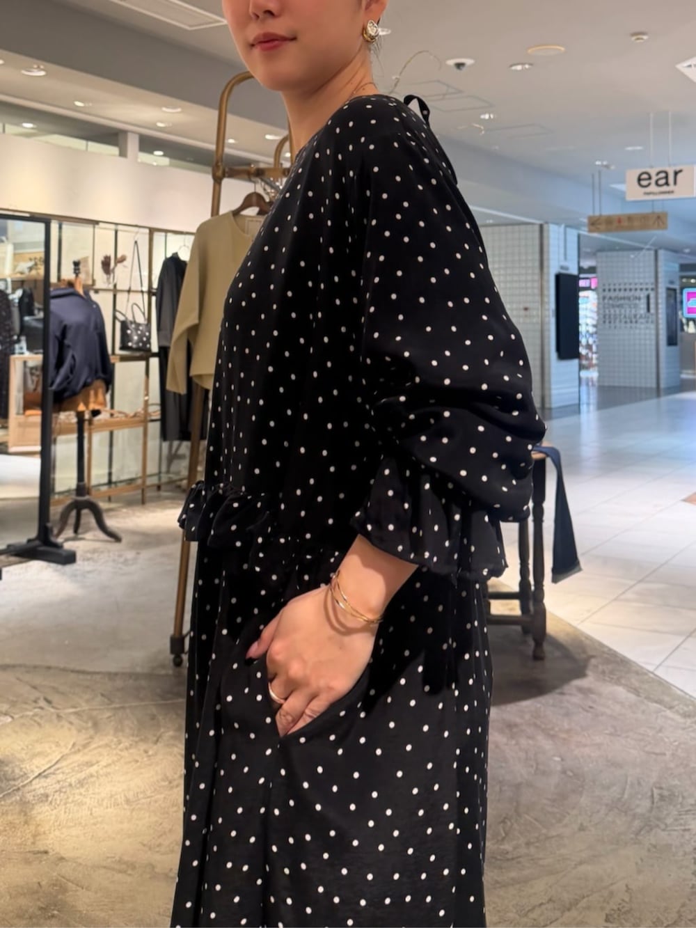 ブラック系のハンドバッグ、ブラック系のワンピースを着用したレディースの春コーディネートの6枚目の写真