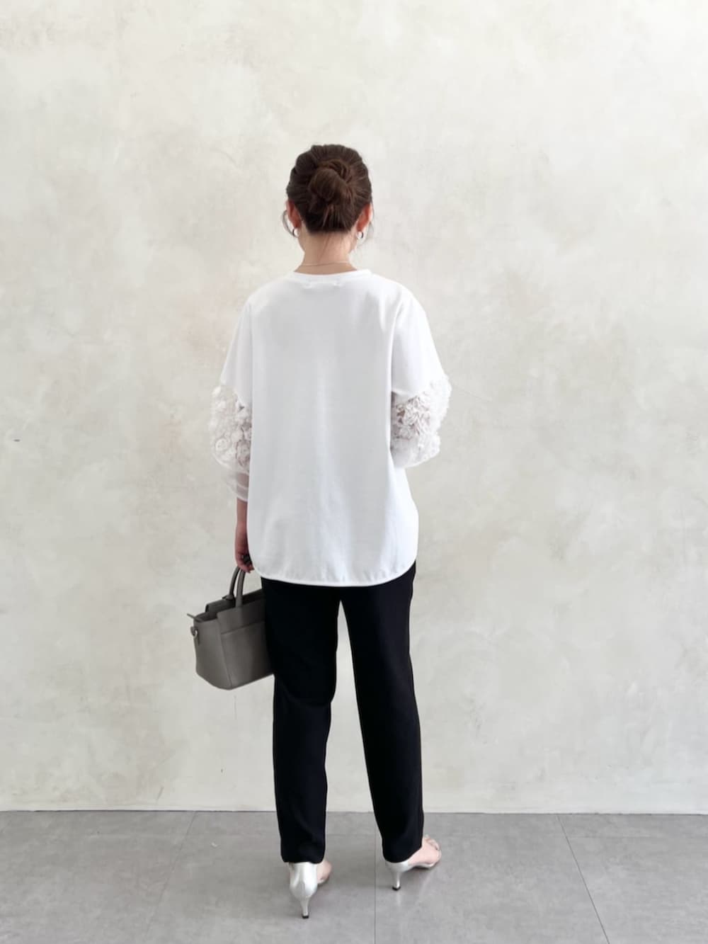 グレー系のハンドバッグ、ブラック系のその他パンツ、ホワイト系のTシャツ/カットソーを着用したレディースの春コーディネートの5枚目の写真